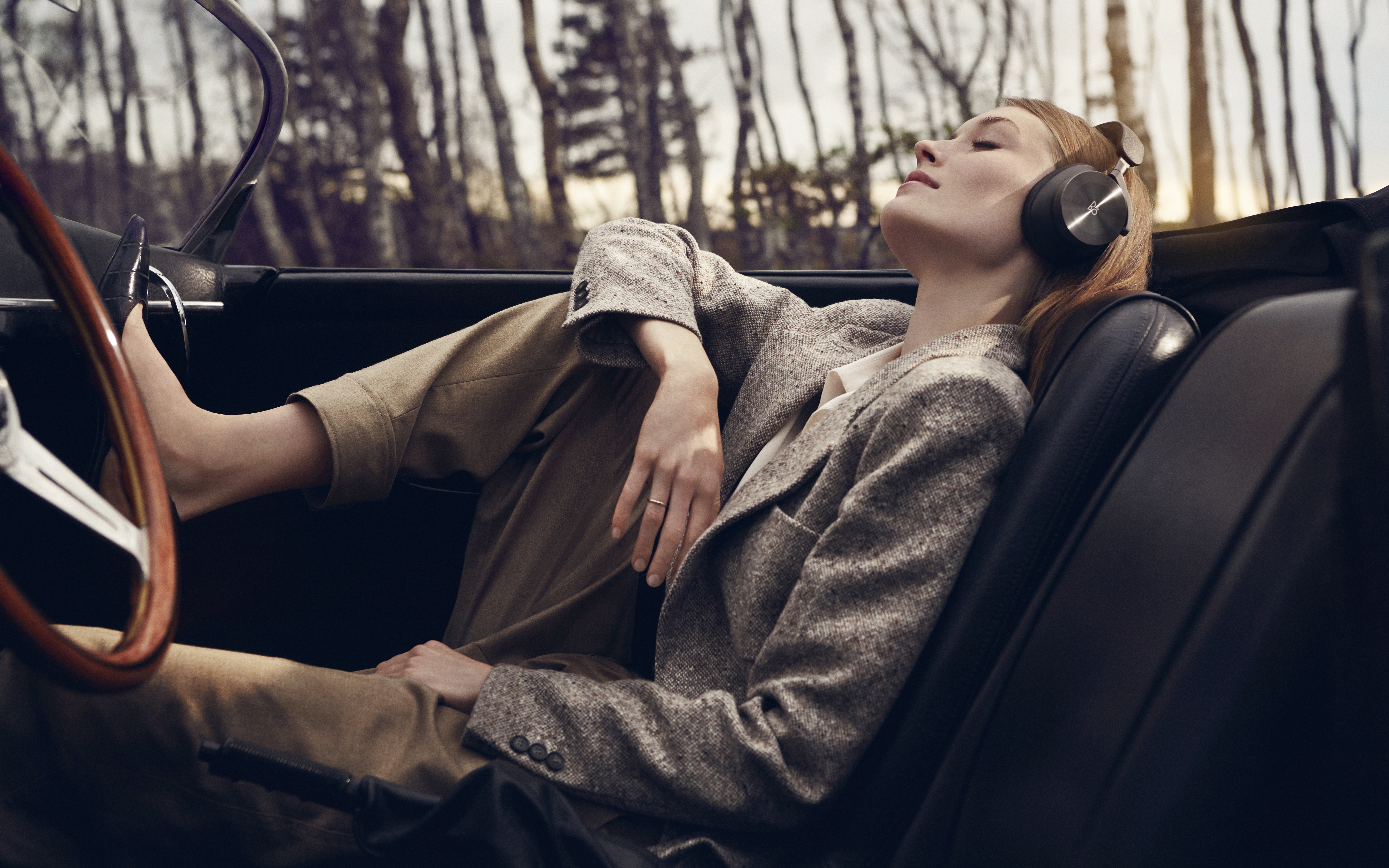 Woman wearing headphones in a convertible car HD Wallpaper