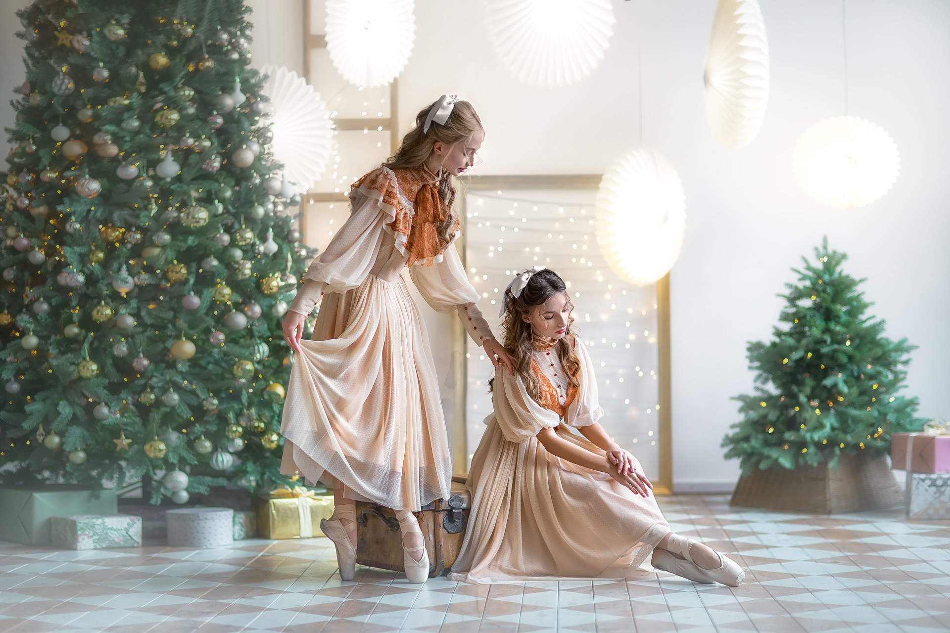 Two ballerinas in vintage dresses by a Christmas tree HD Wallpaper