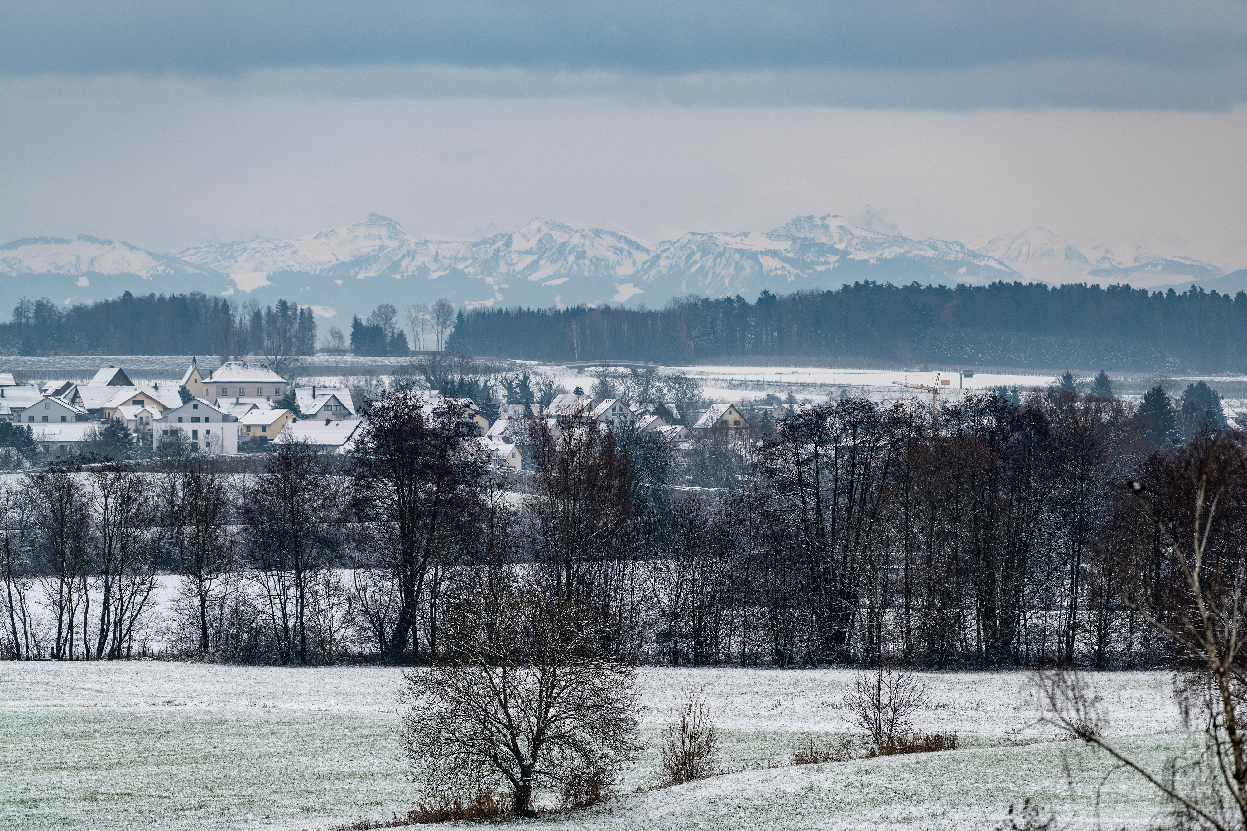 Village and snow-covered mountains in winter HD Wallpaper