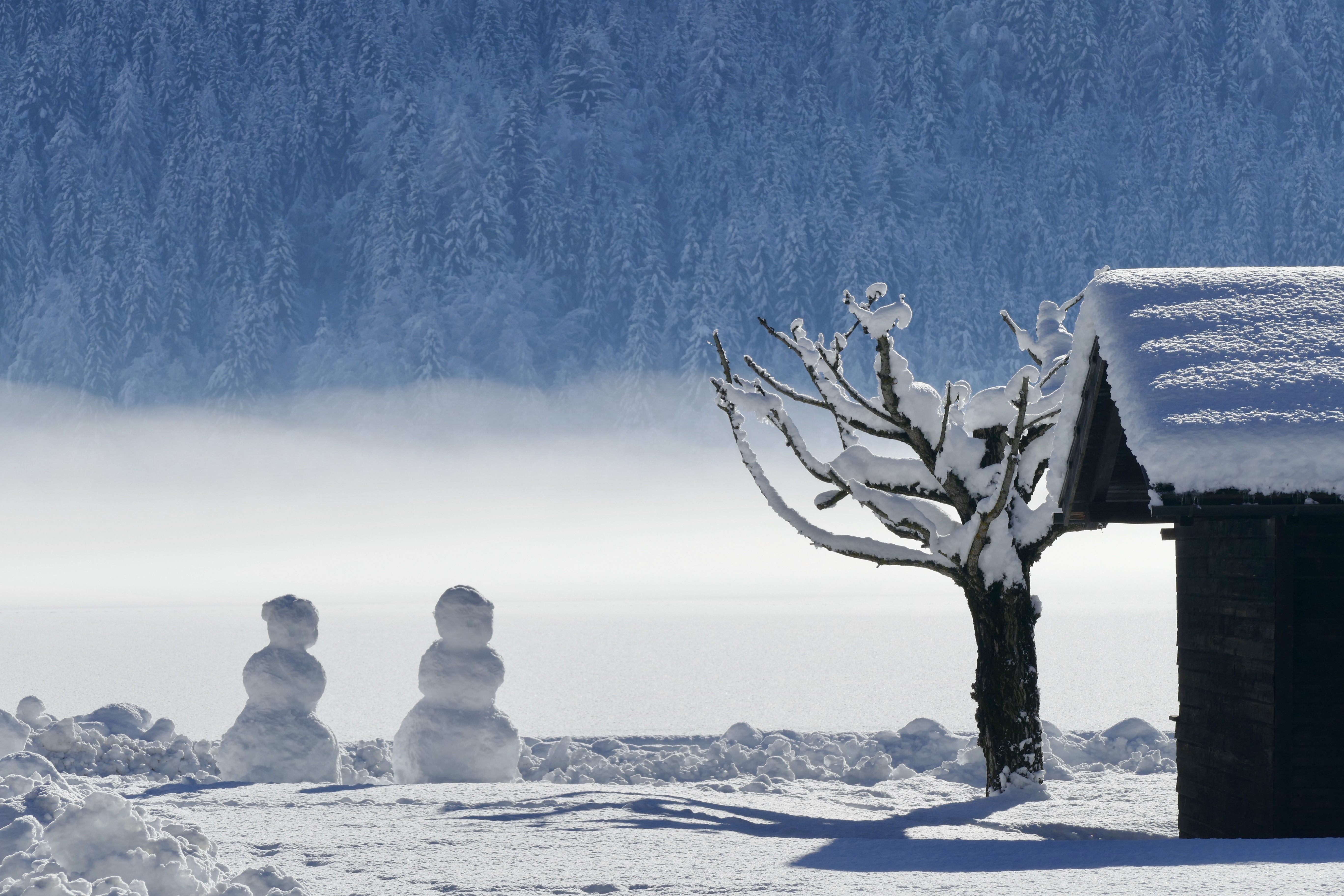 Snowmen and a cabin in a snowy landscape HD Wallpaper