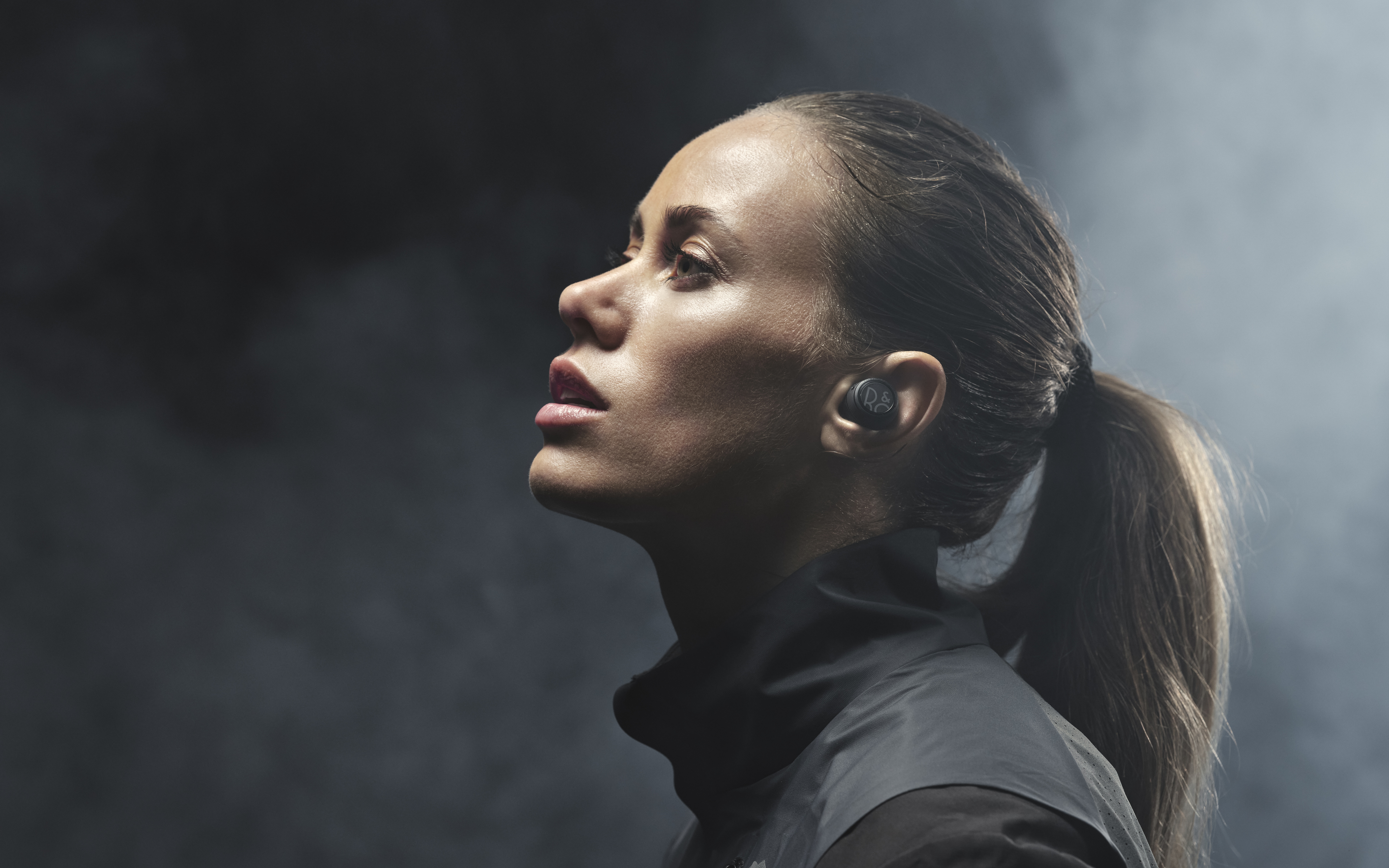 Woman with earbuds in profile HD Wallpaper