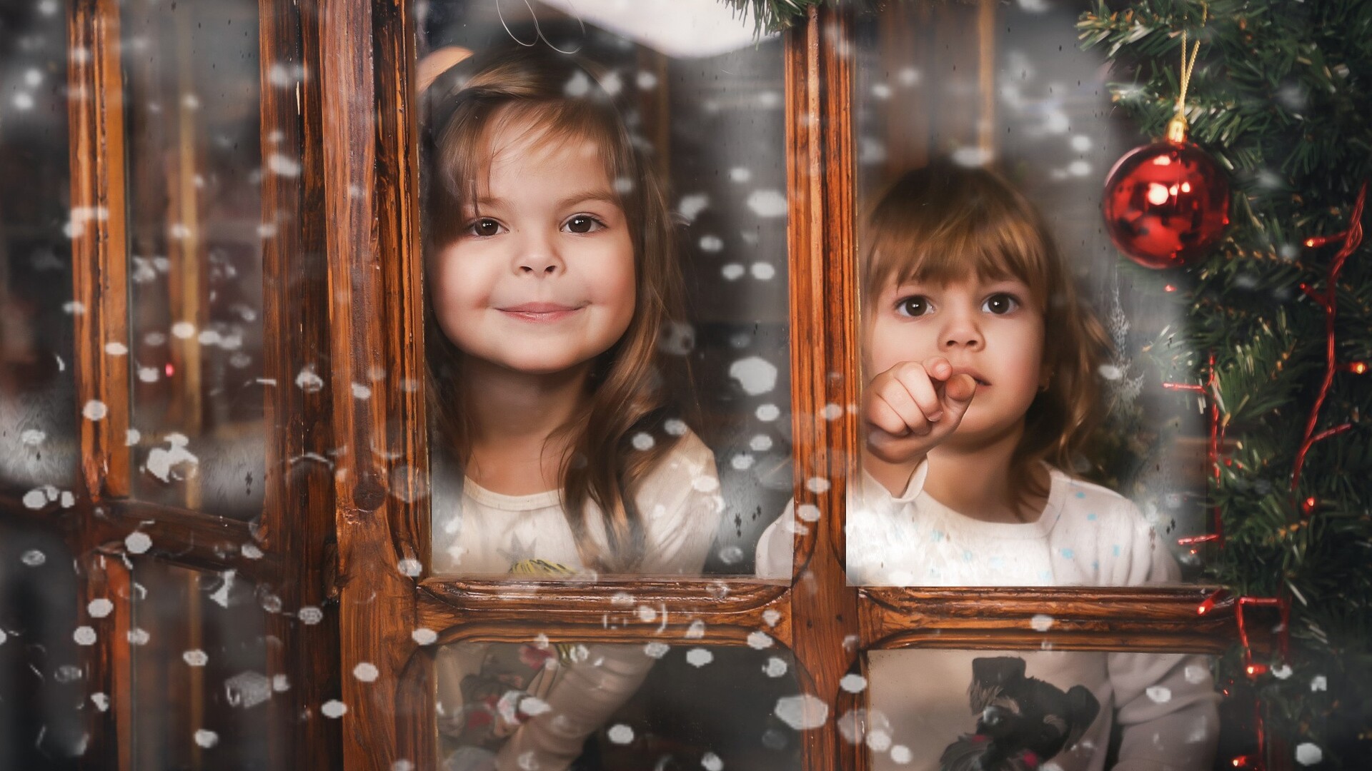 Two young girls looking out a window at Christmas HD Wallpaper