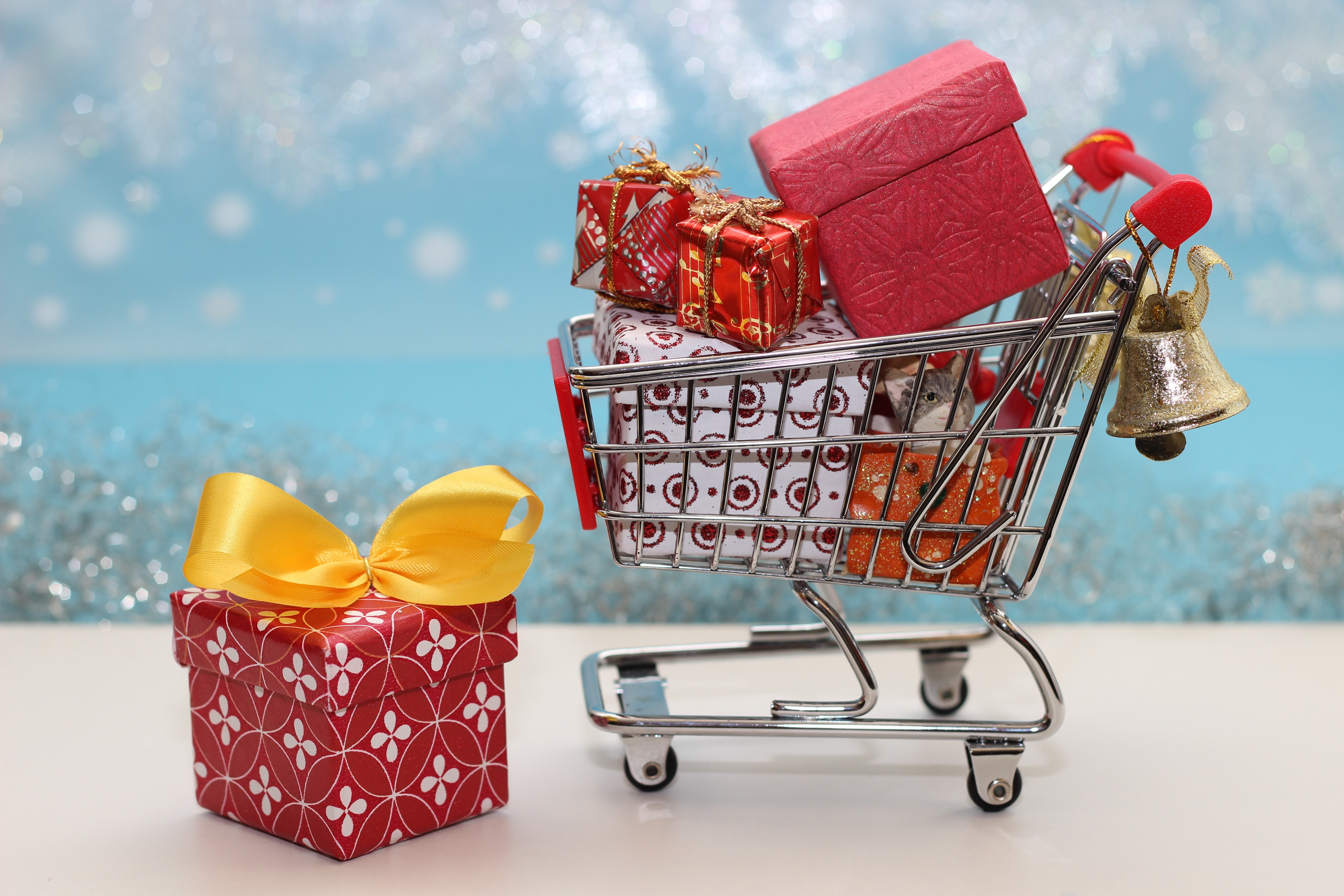 Christmas gifts in a shopping cart with a bell HD Wallpaper