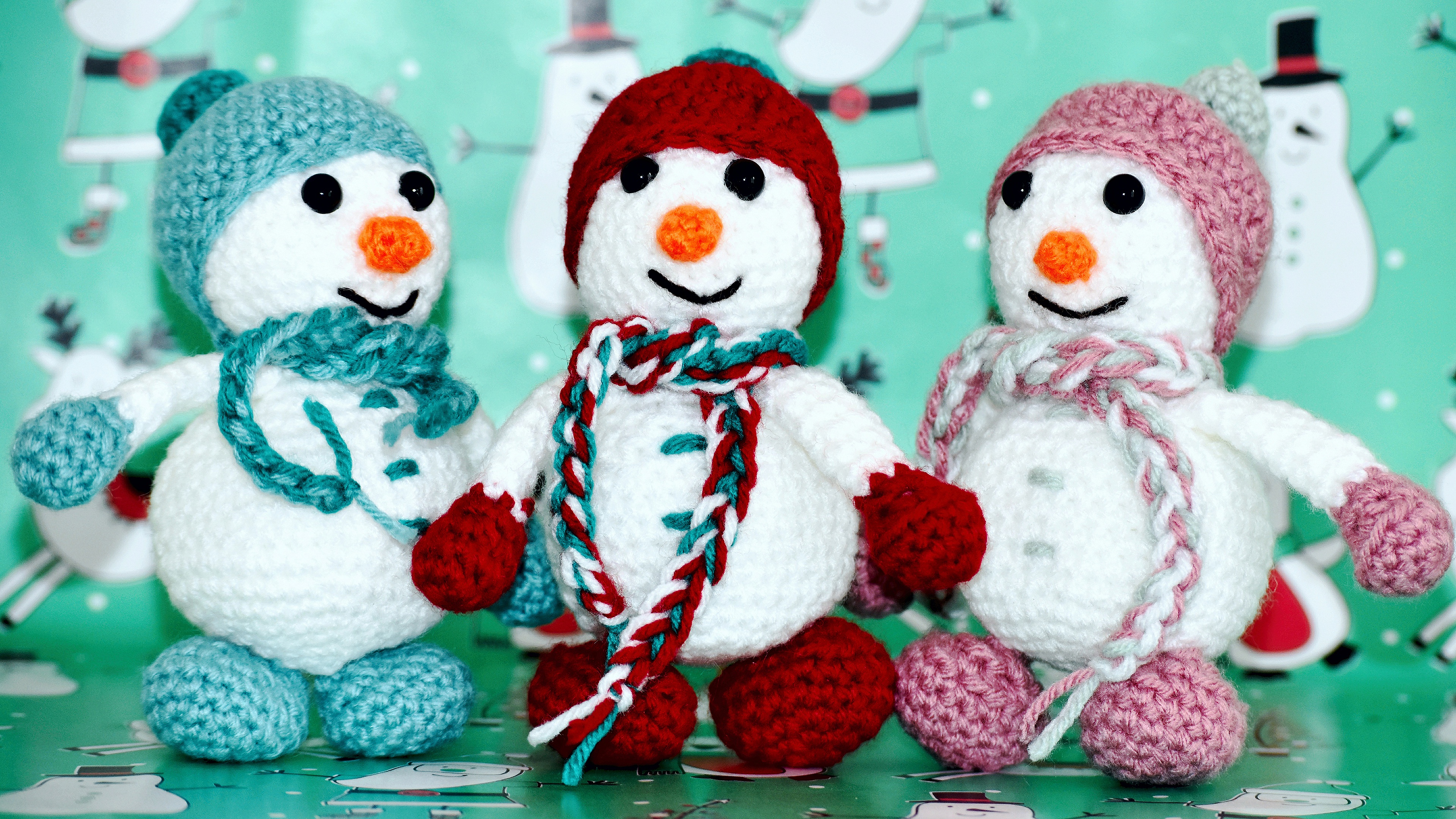 Three crocheted snowmen toys with hats and scarves HD Wallpaper