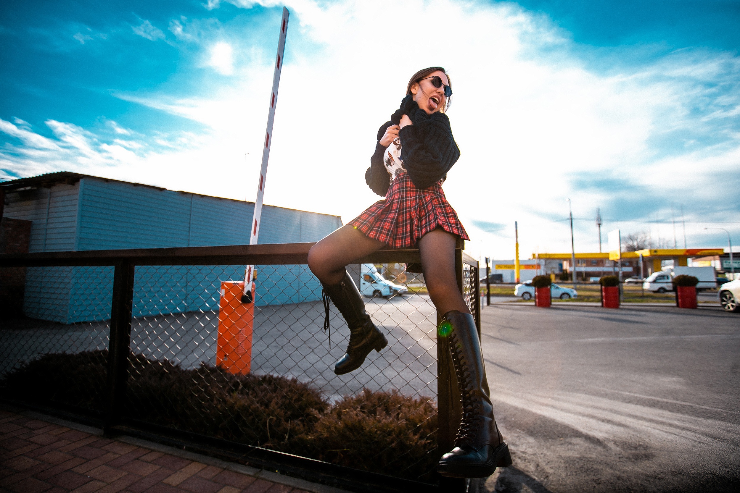 Woman in skirt and boots sitting on fence HD Wallpaper