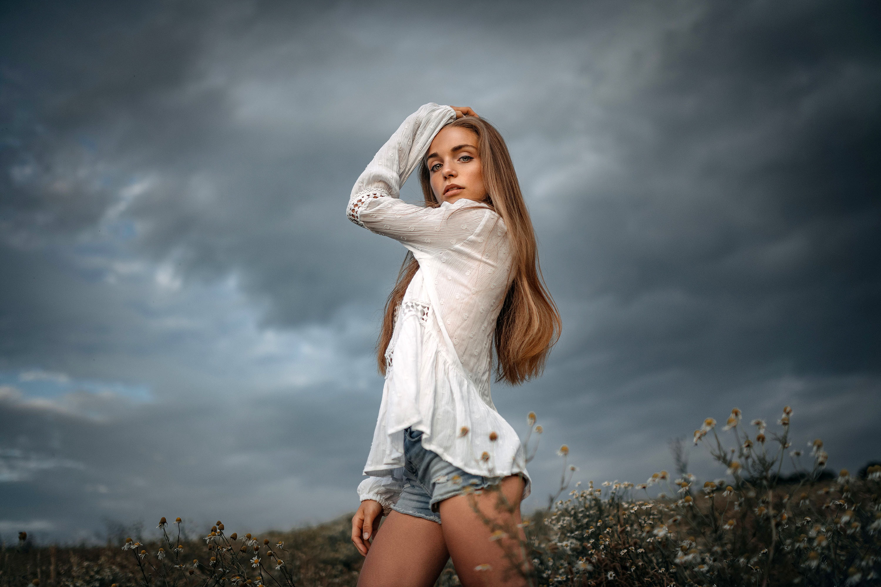 Model with long hair wearing shorts in a field HD Wallpaper