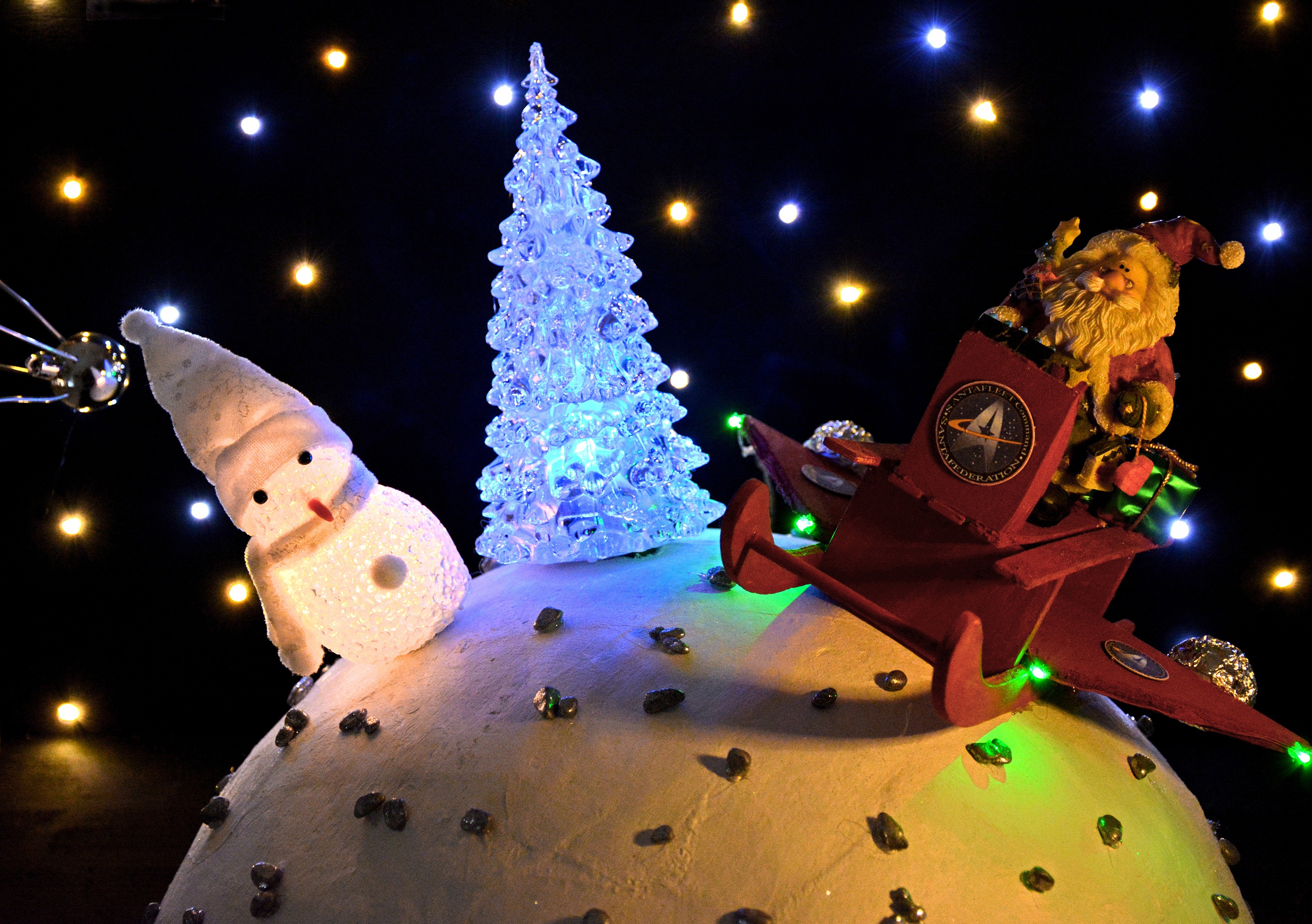 Santa and Snowman on a snowy planet with Christmas lights HD Wallpaper