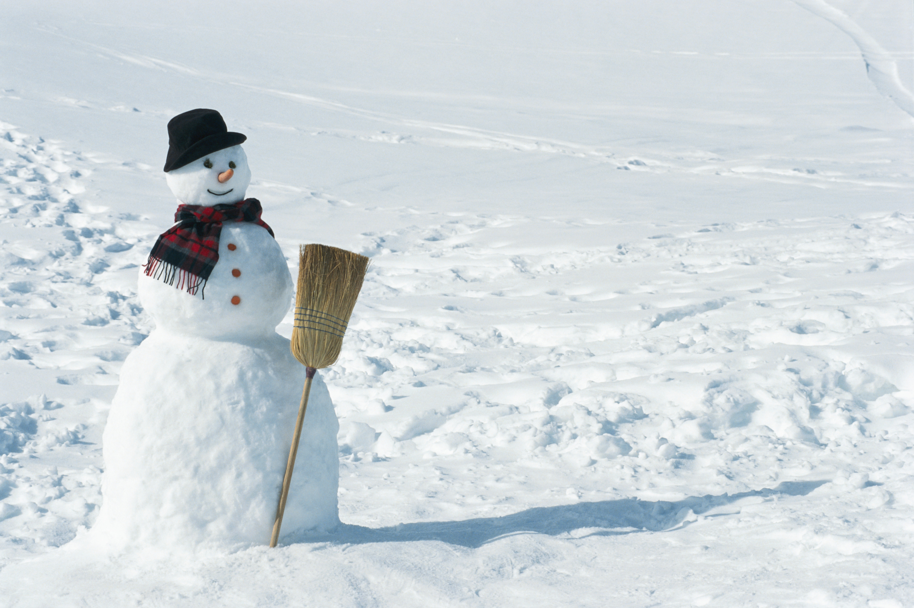 Snowman with hat, scarf, and broomstick in snow HD Wallpaper