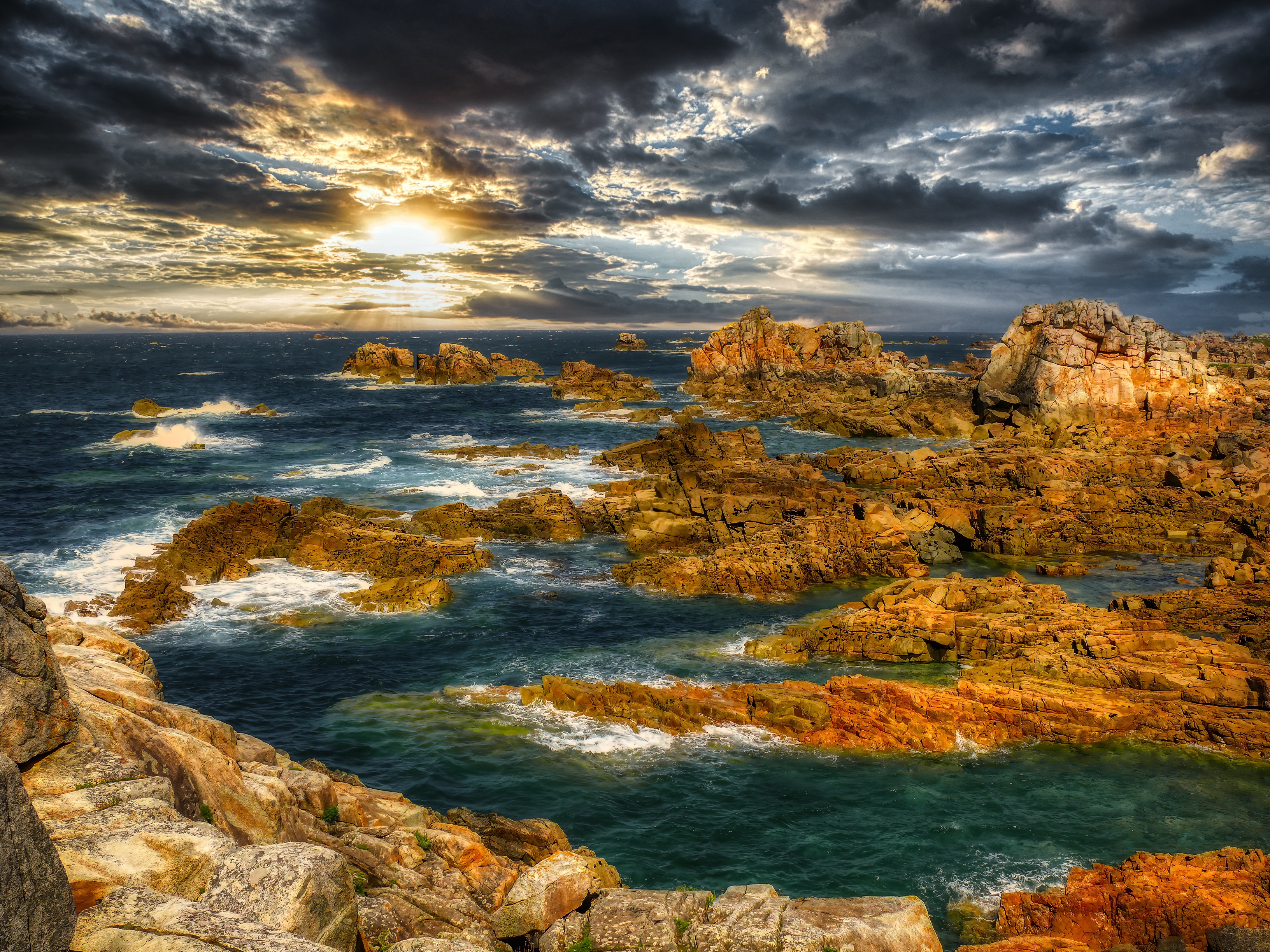 Rocky coastline with dramatic clouds at sunset HD Wallpaper