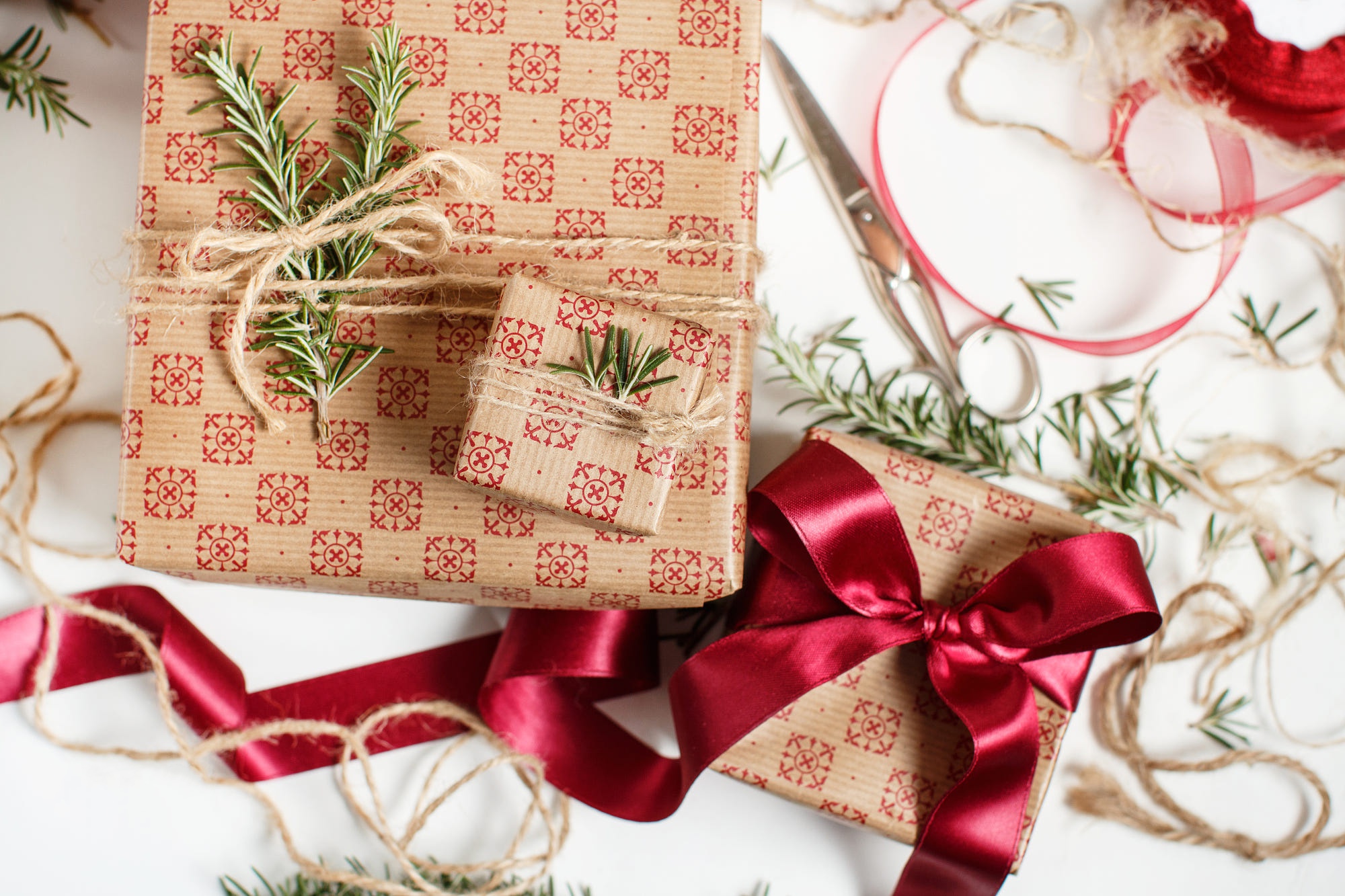Christmas gifts wrapped with red patterned paper and rosemary sprigs HD Wallpaper