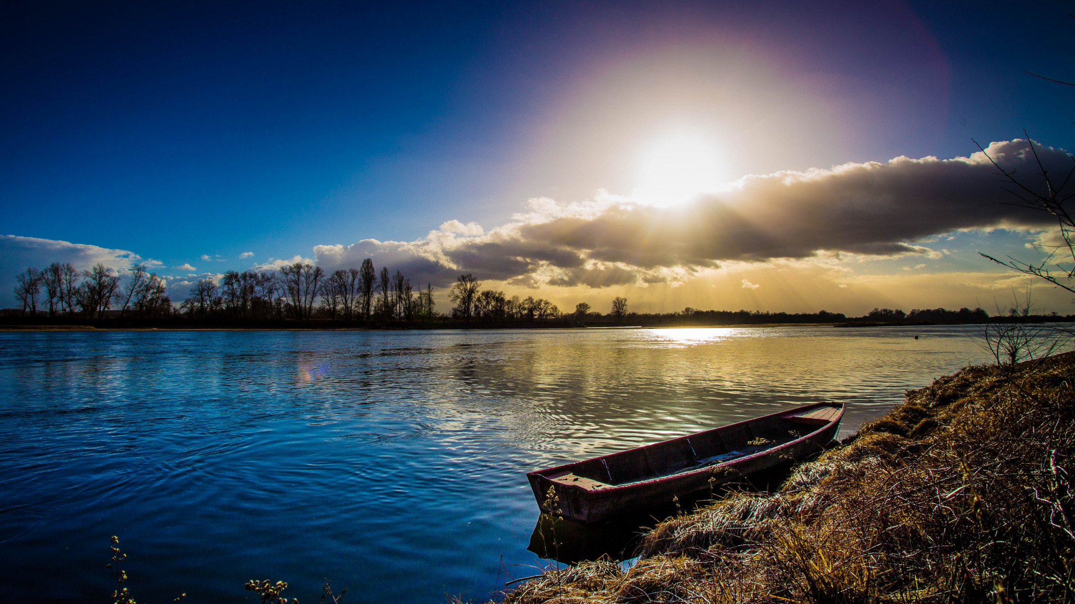 Boat on a river with sun and clouds HD Wallpaper