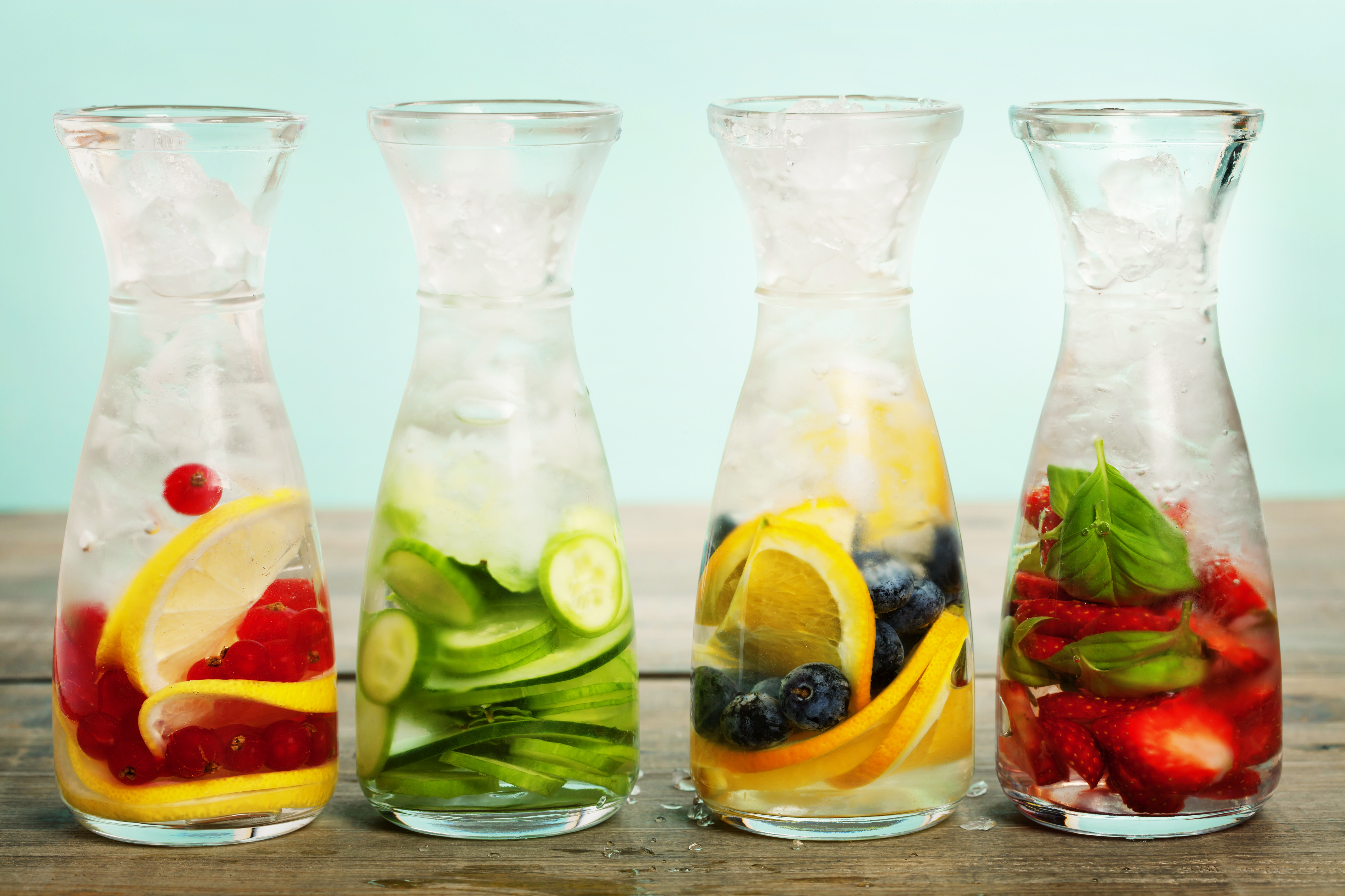 Four carafes of infused water with fruits and ice HD Wallpaper