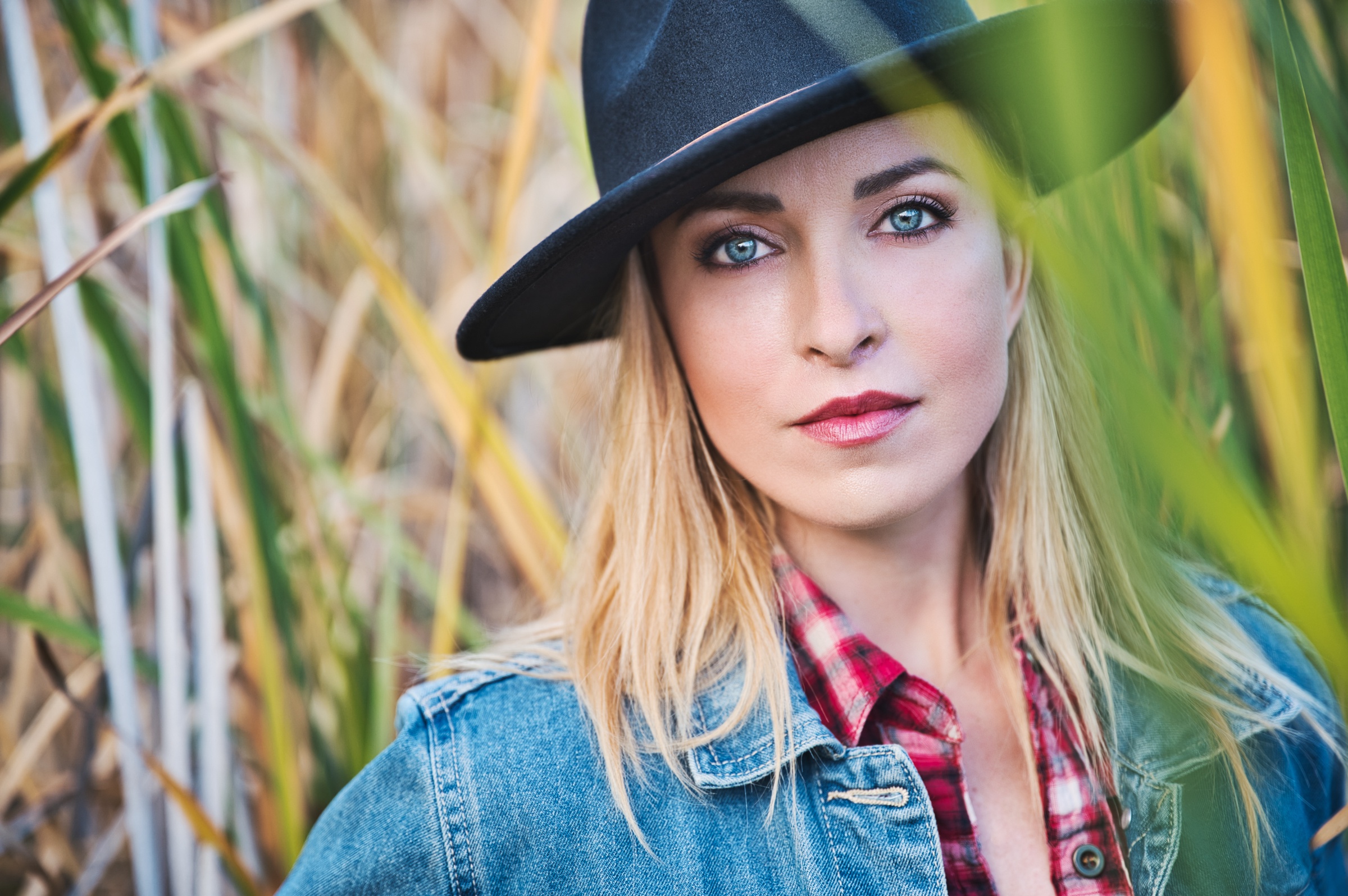 Woman with blue eyes wearing a hat and denim jacket HD Wallpaper