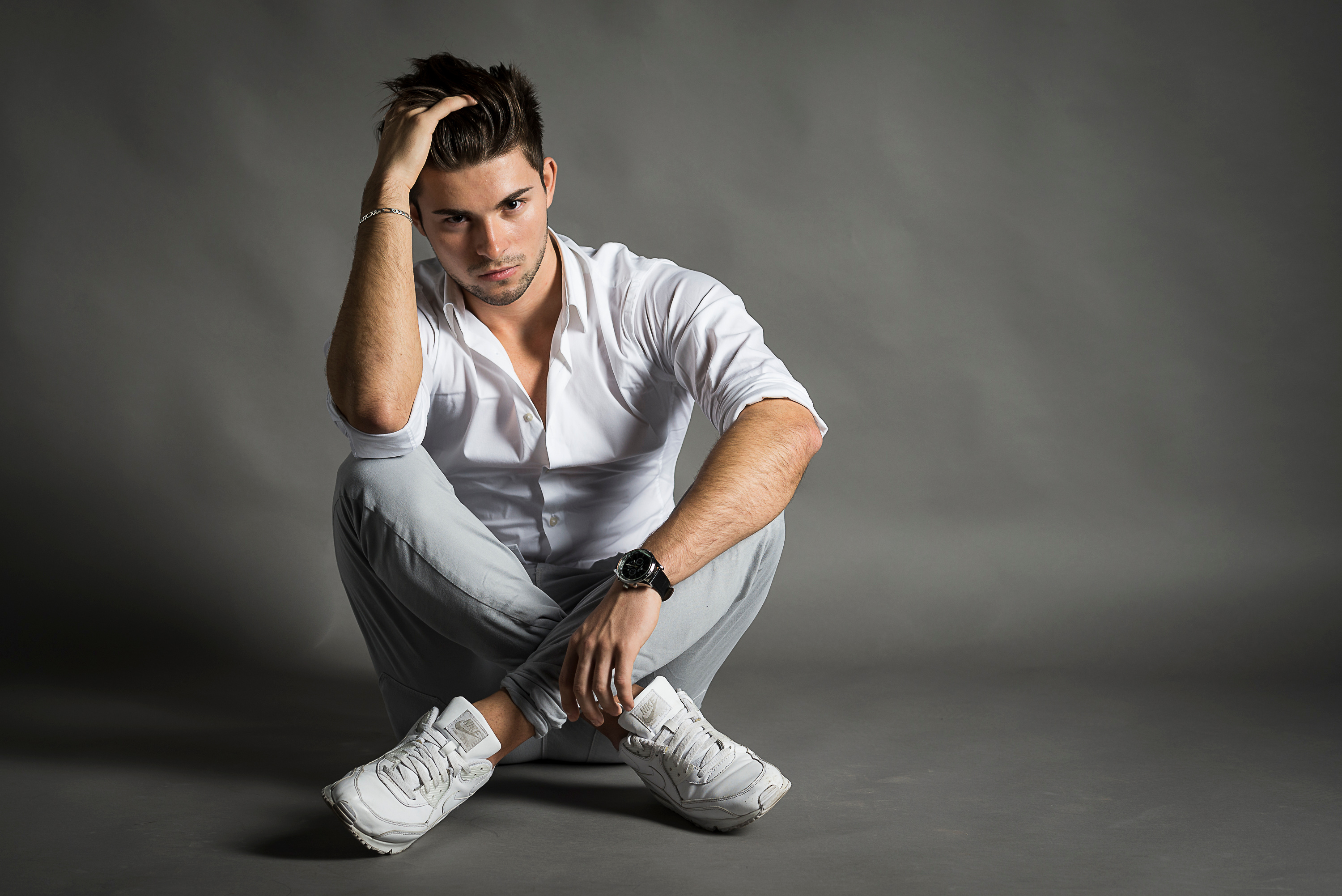 Man in white shirt sitting on gray background HD Wallpaper