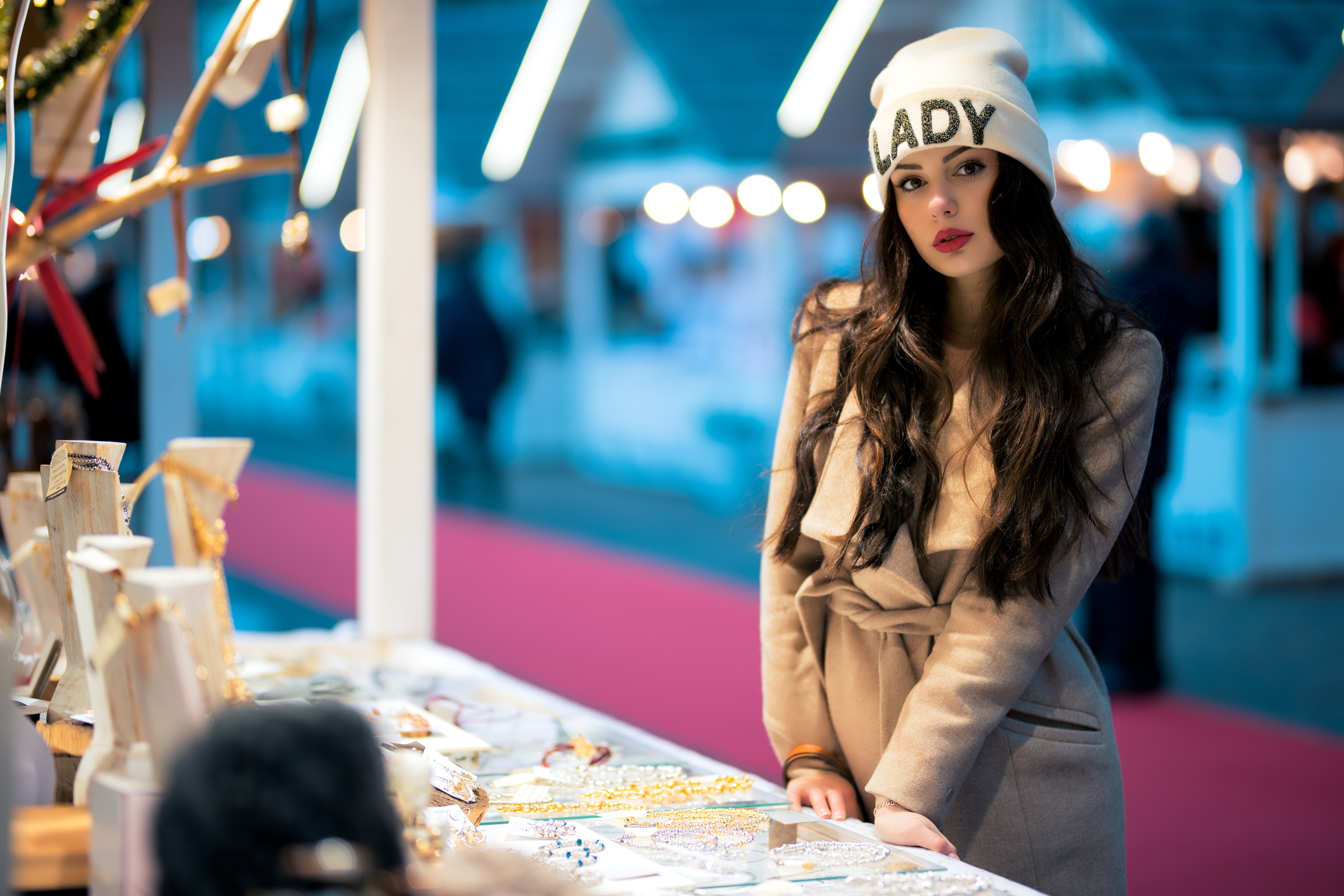 Woman wearing a beanie at a market stall HD Wallpaper