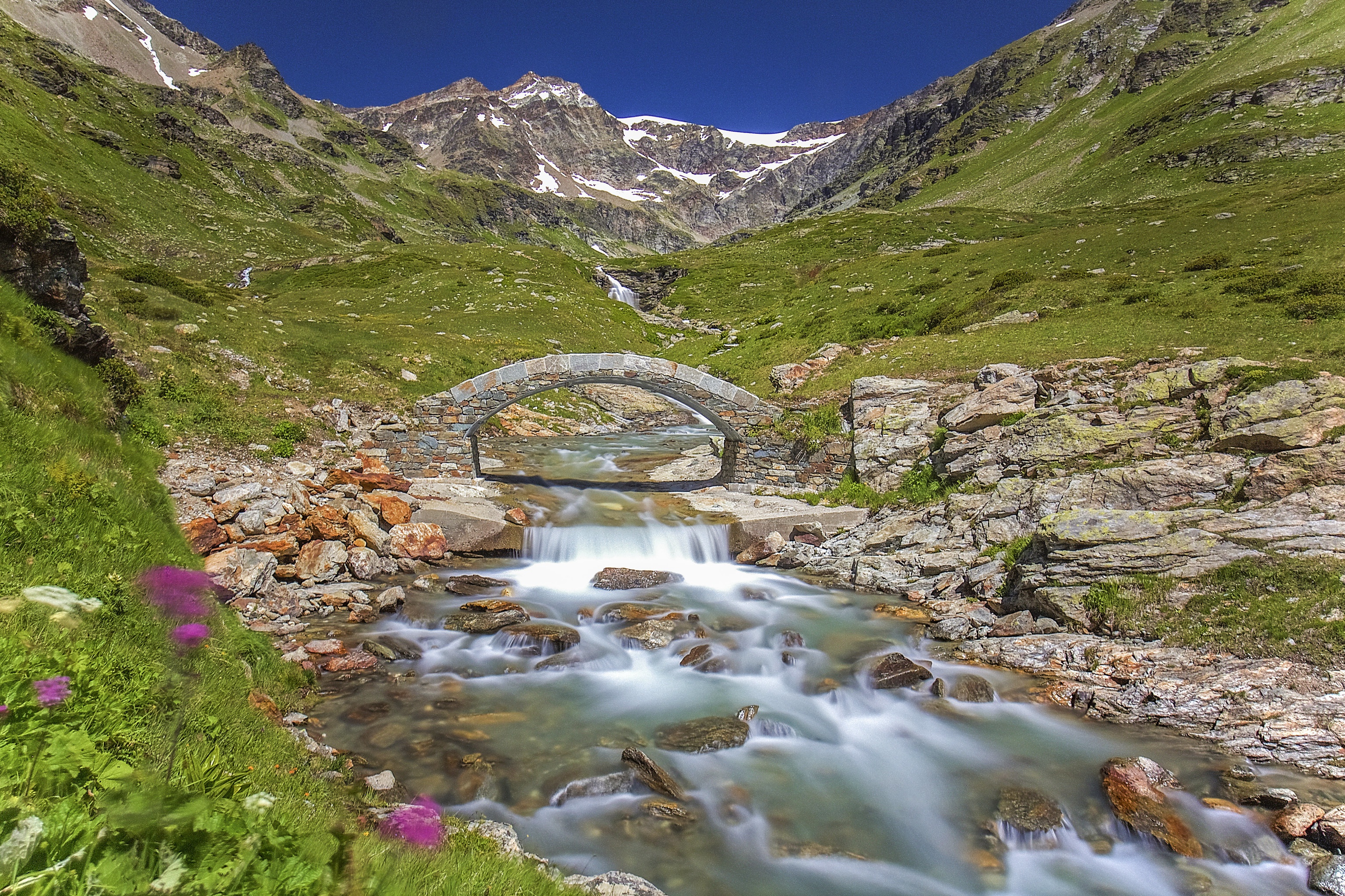 Stone bridge over a stream in the Italian Alps HD Wallpaper