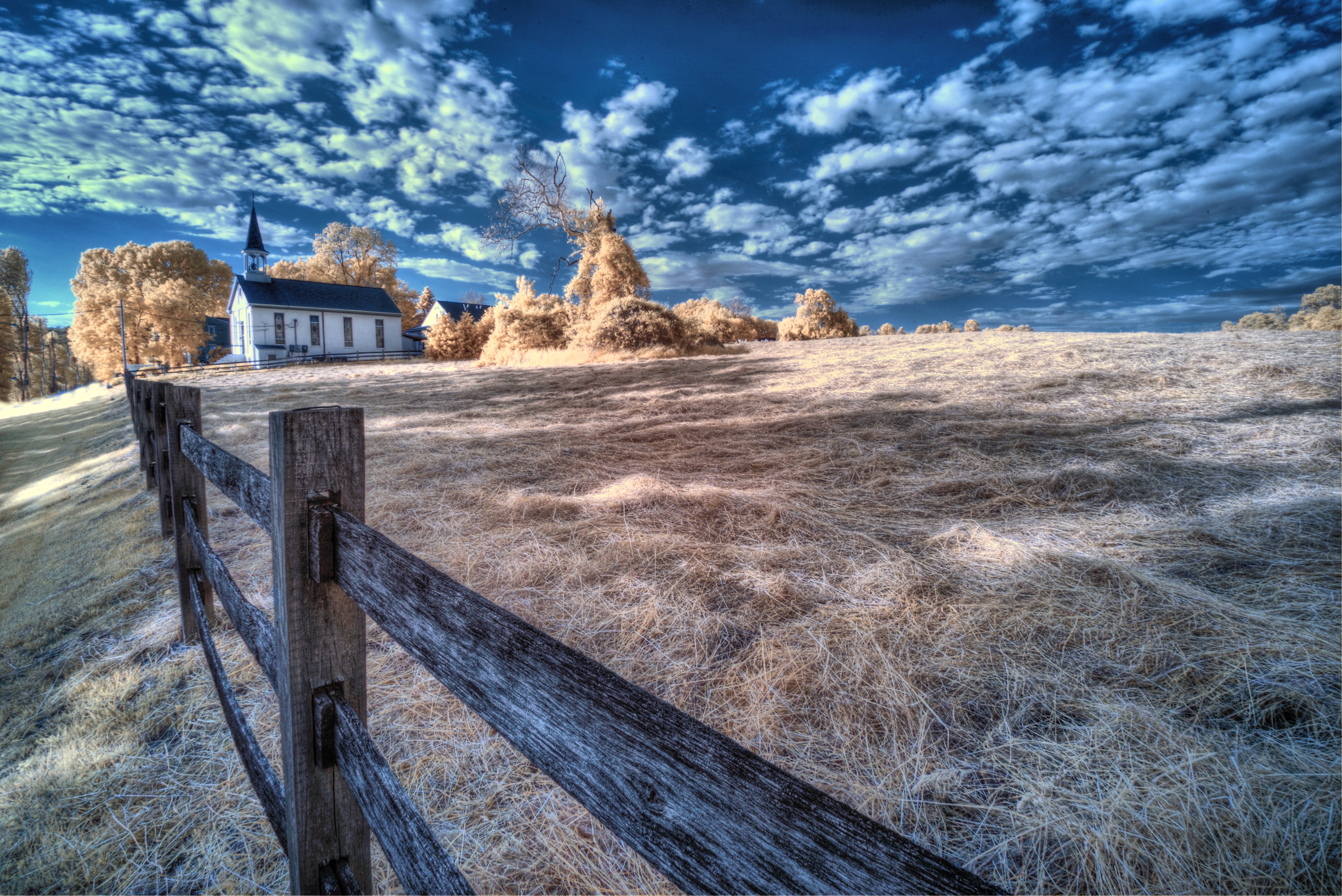 Church with fence in field under blue sky with clouds HD Wallpaper