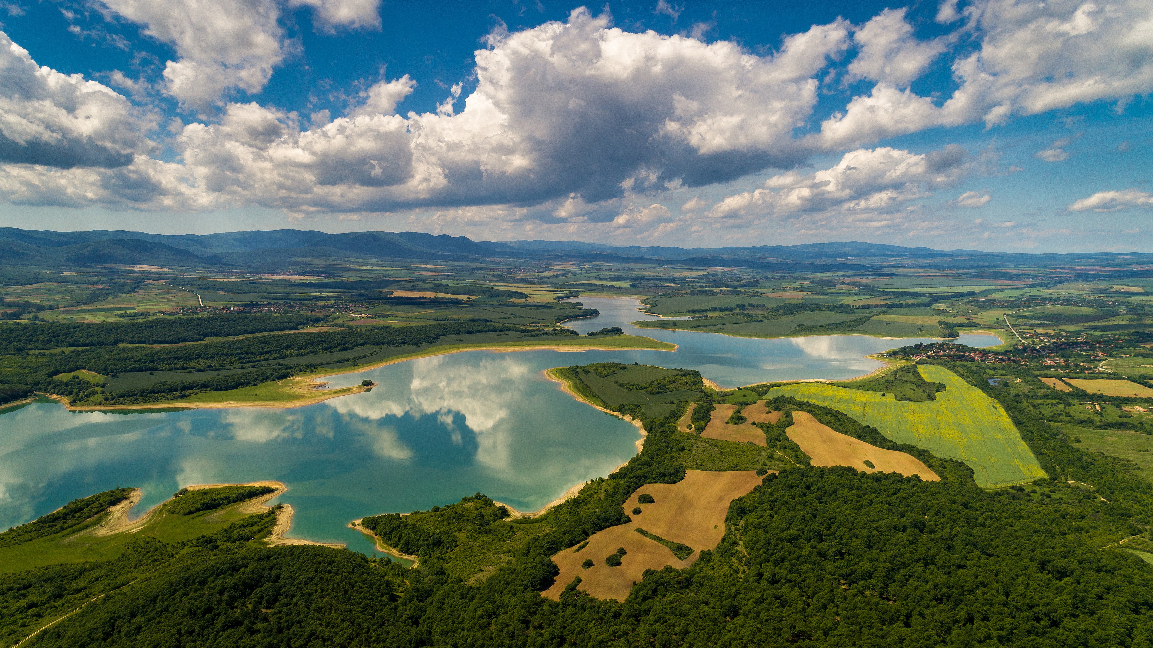 Aerial view of a lake and surrounding landscape HD Wallpaper