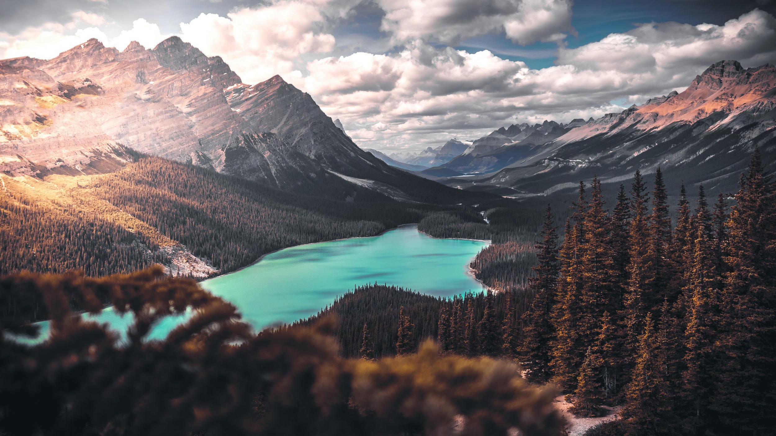 Turquoise lake surrounded by pine forest and mountains HD Wallpaper