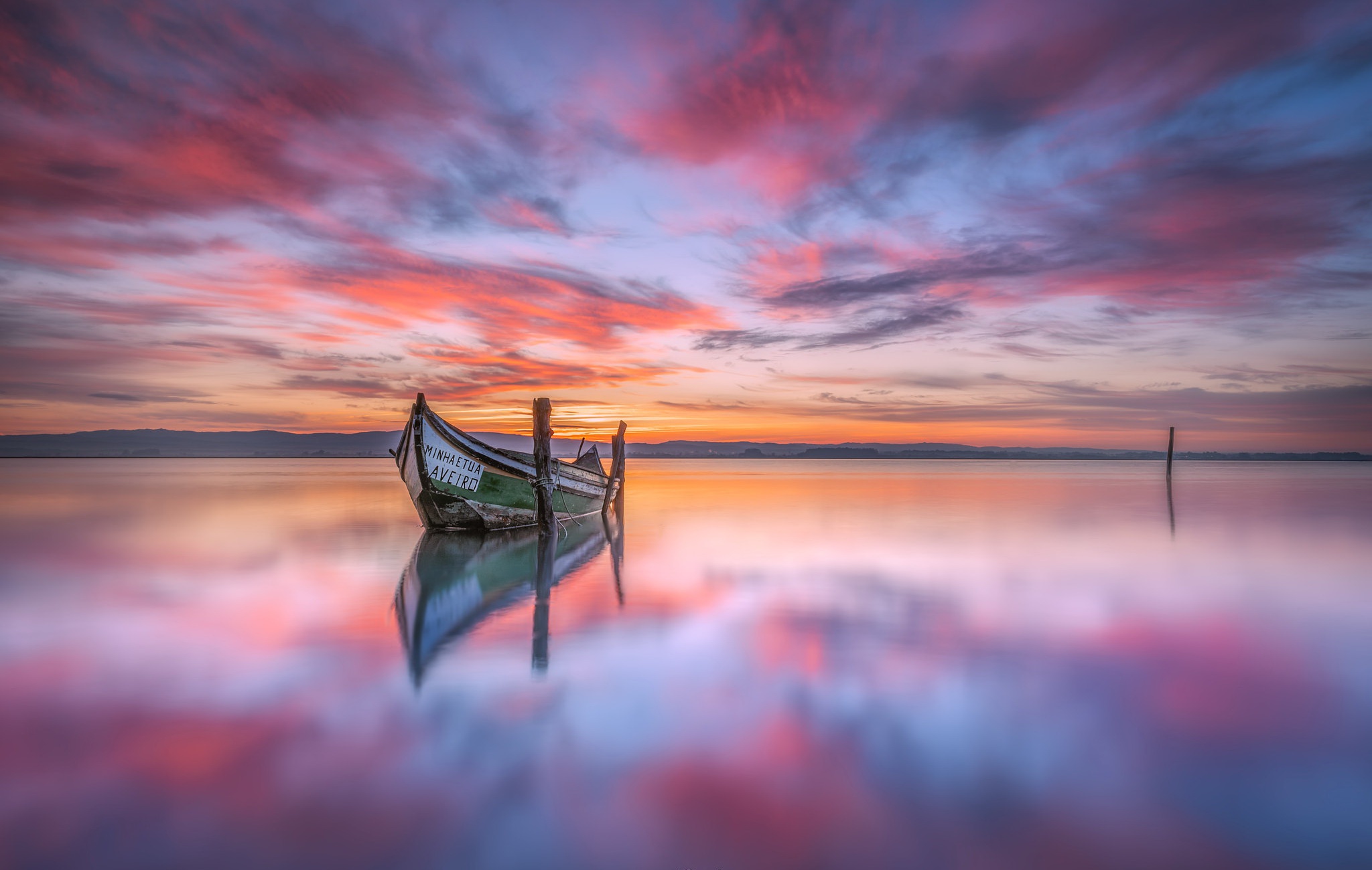 Boat on a lake at sunset with colorful clouds HD Wallpaper