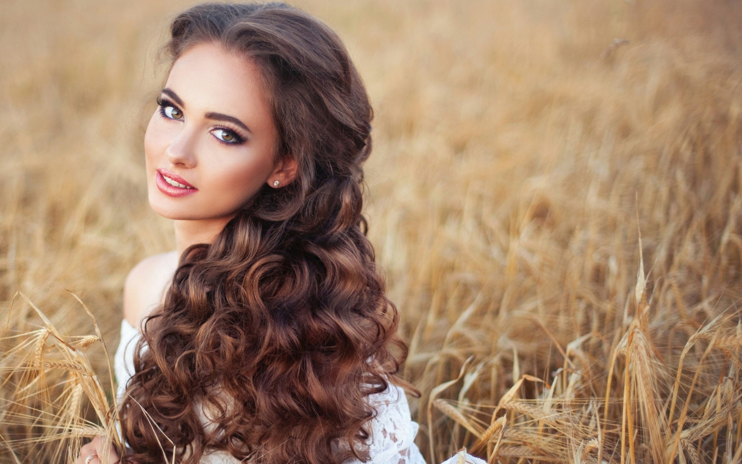 Brunette woman with long curly hair in a wheat field HD Wallpaper