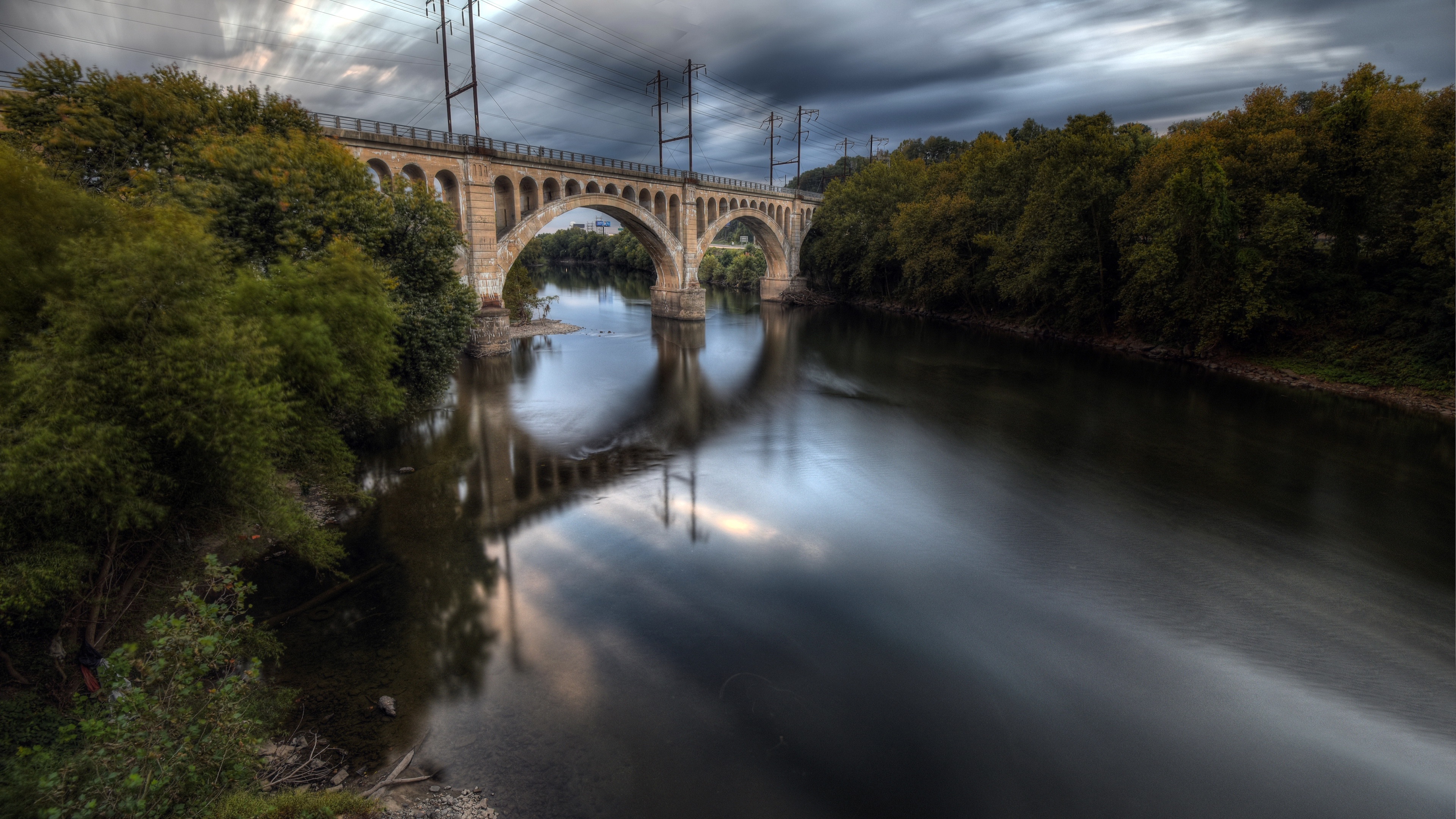 Bridge over a river with trees and stormy sky HD Wallpaper