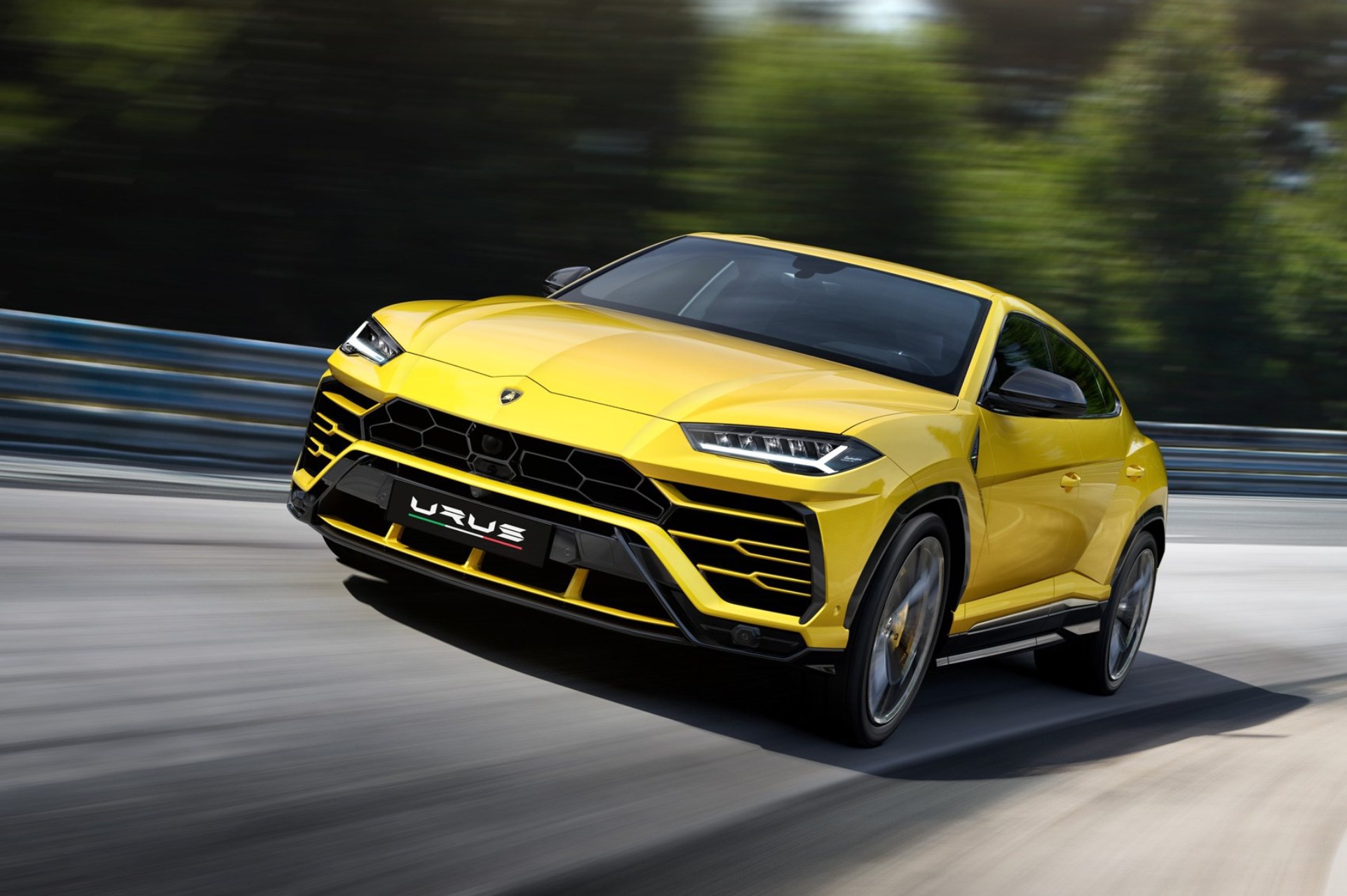 Yellow Lamborghini Urus driving on a track HD Wallpaper
