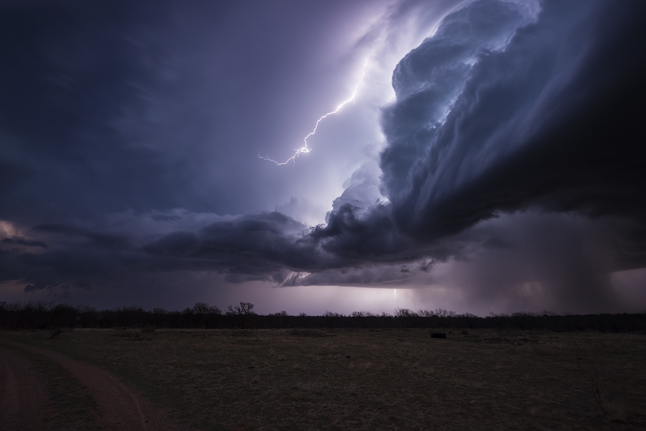 Lightning strikes a stormy sky over a field HD Wallpaper