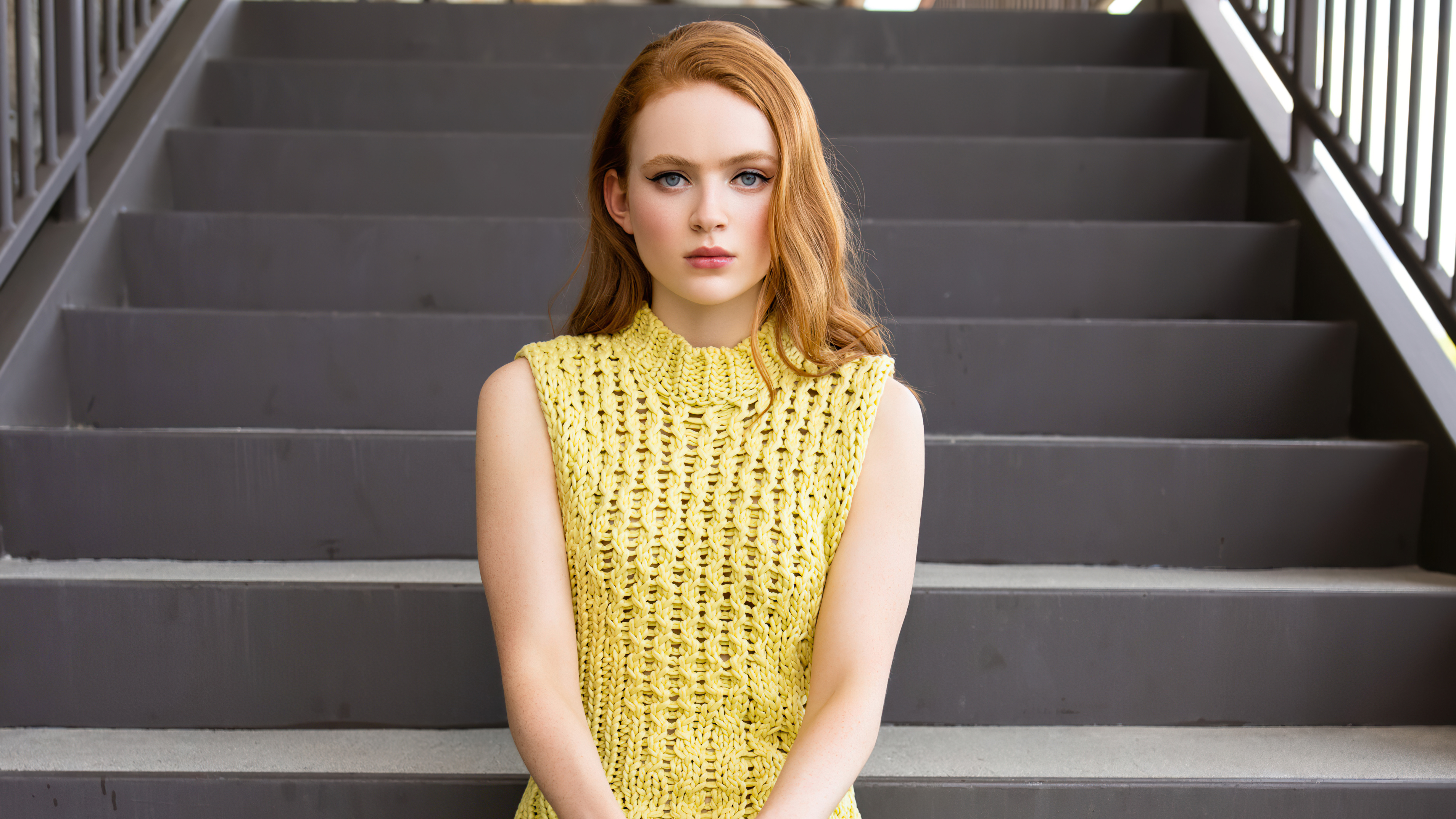 Sadie Sink in yellow knit top on stairs HD Wallpaper