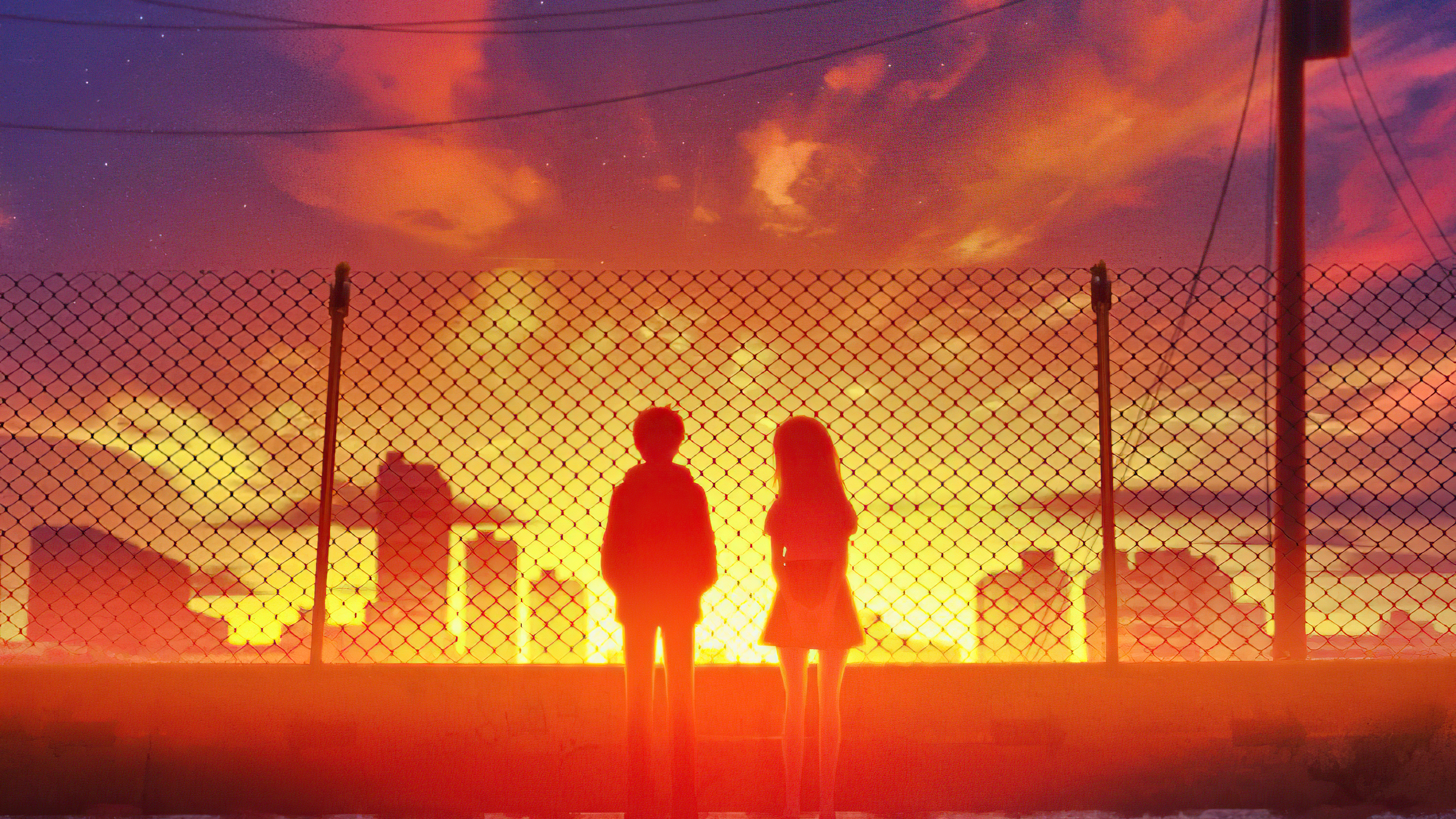 Couple watching sunset behind fence HD Wallpaper