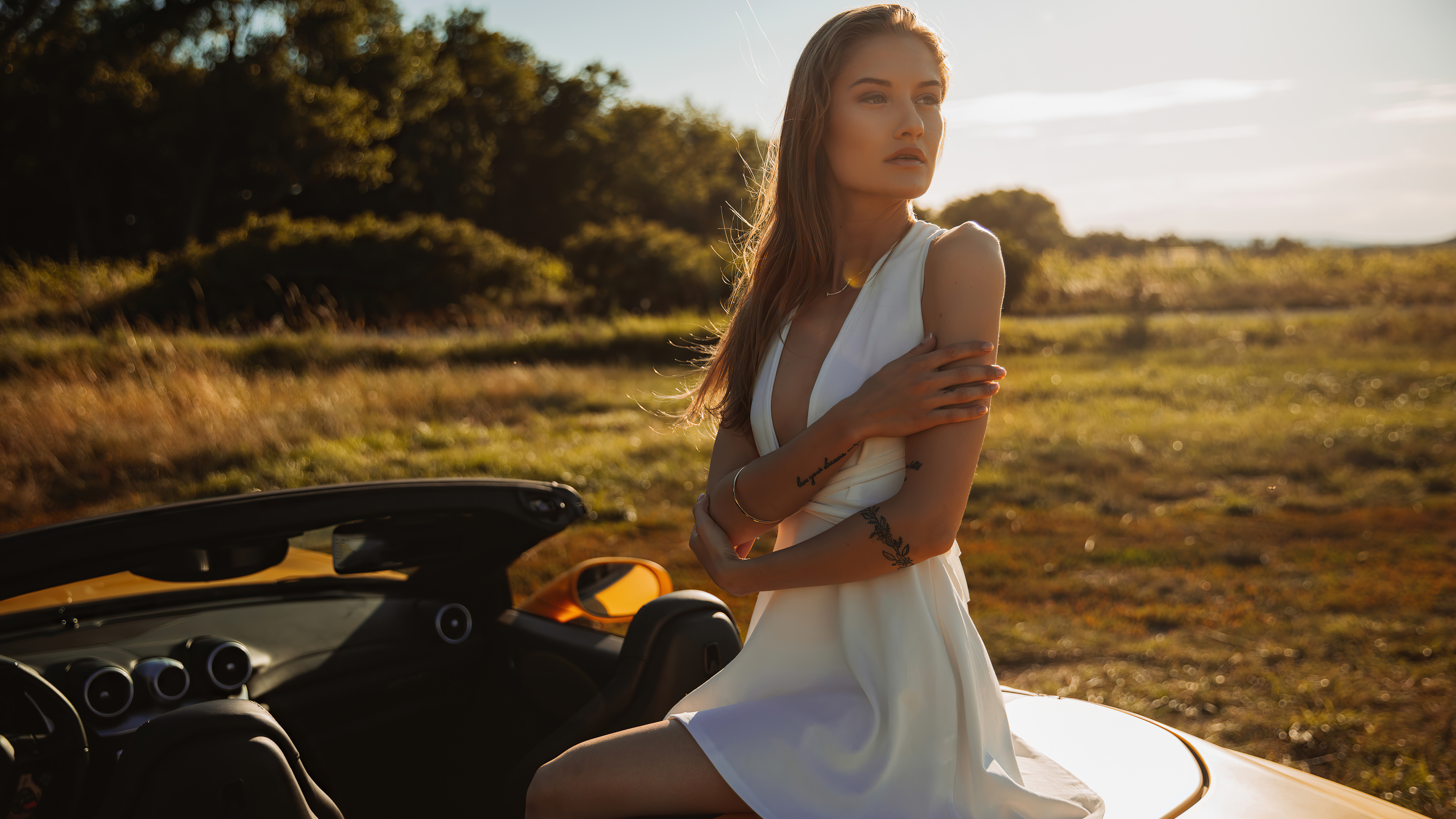 Model in white dress by a convertible car HD Wallpaper