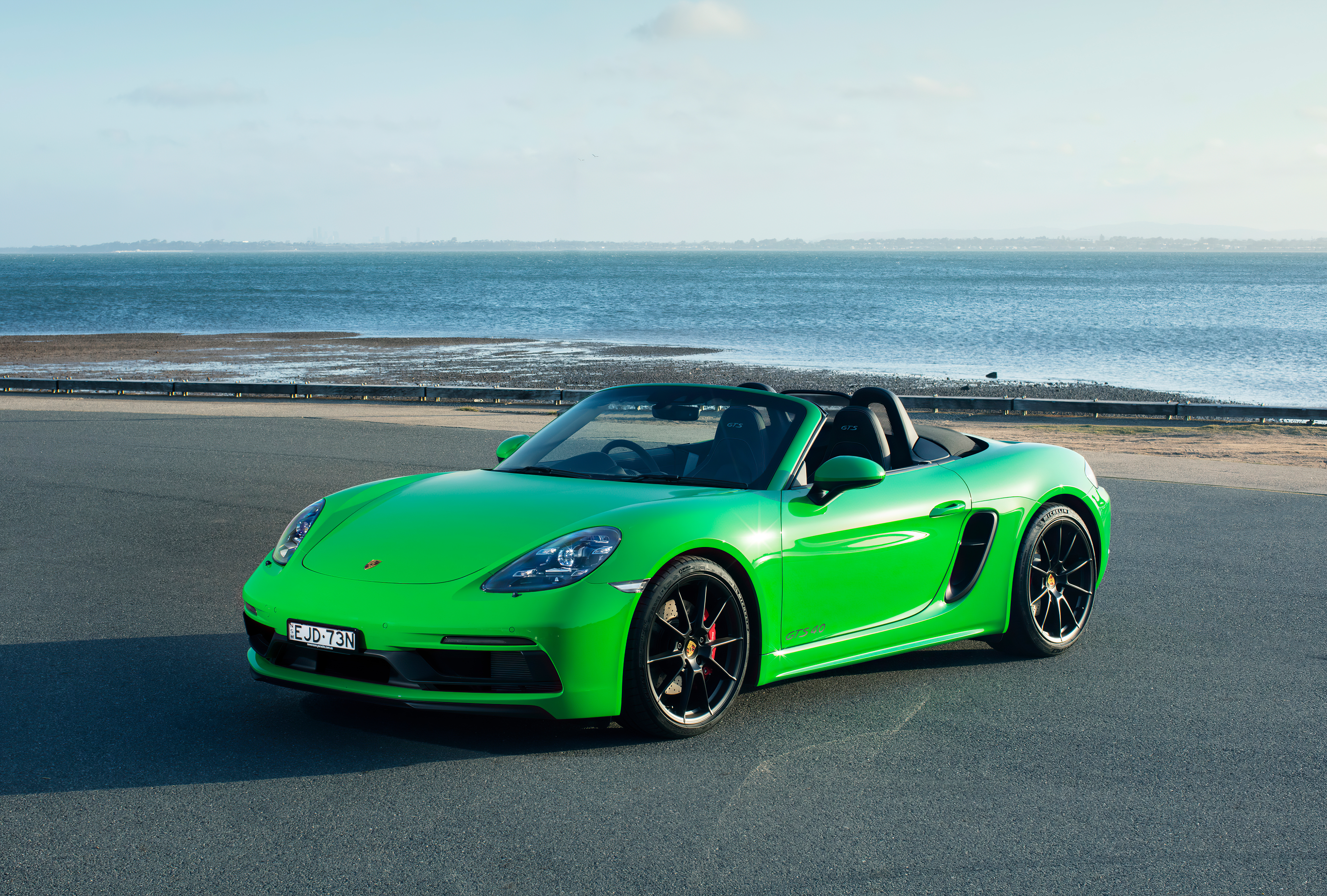 Green Porsche 718 Boxster parked by the sea HD Wallpaper