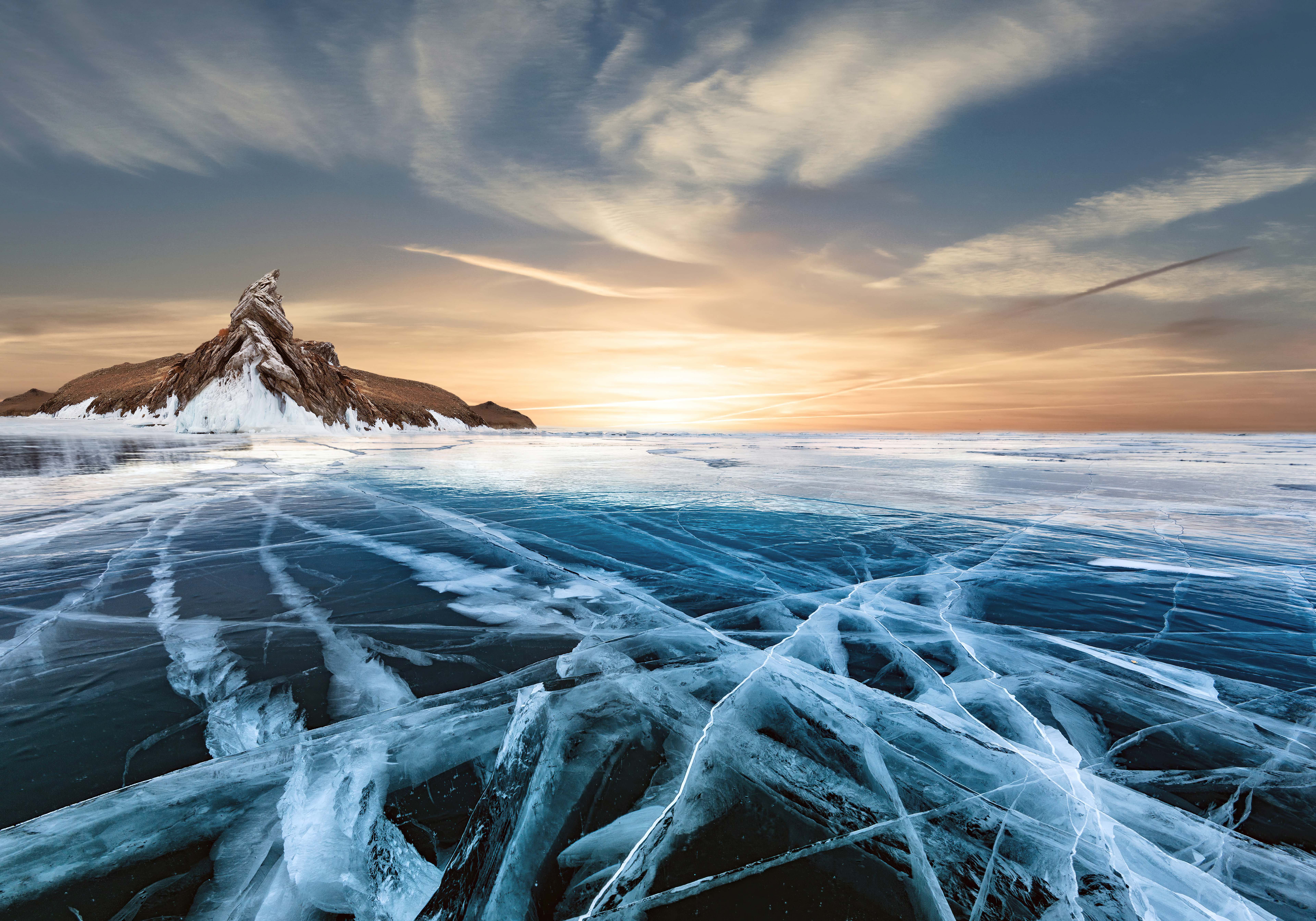 Cracked ice on Baikal lake with mountain island at sunset HD Wallpaper