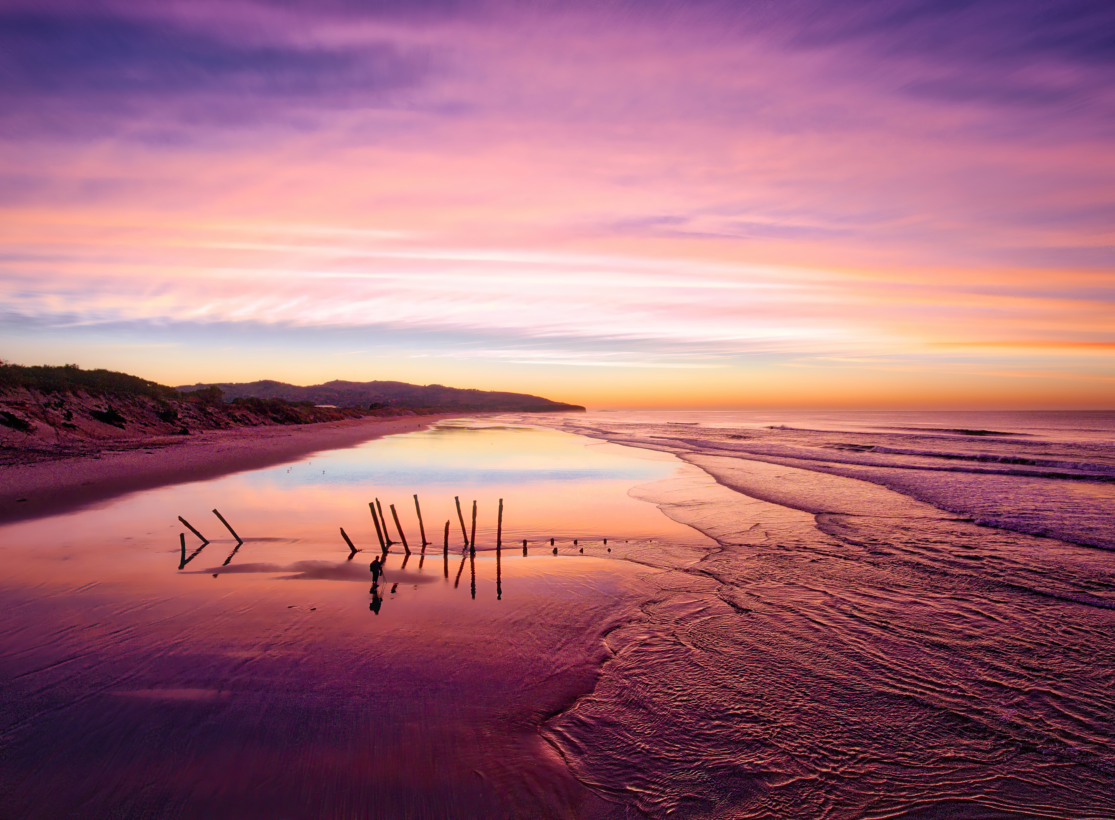 Beach at sunrise with colorful sky and ocean waves HD Wallpaper