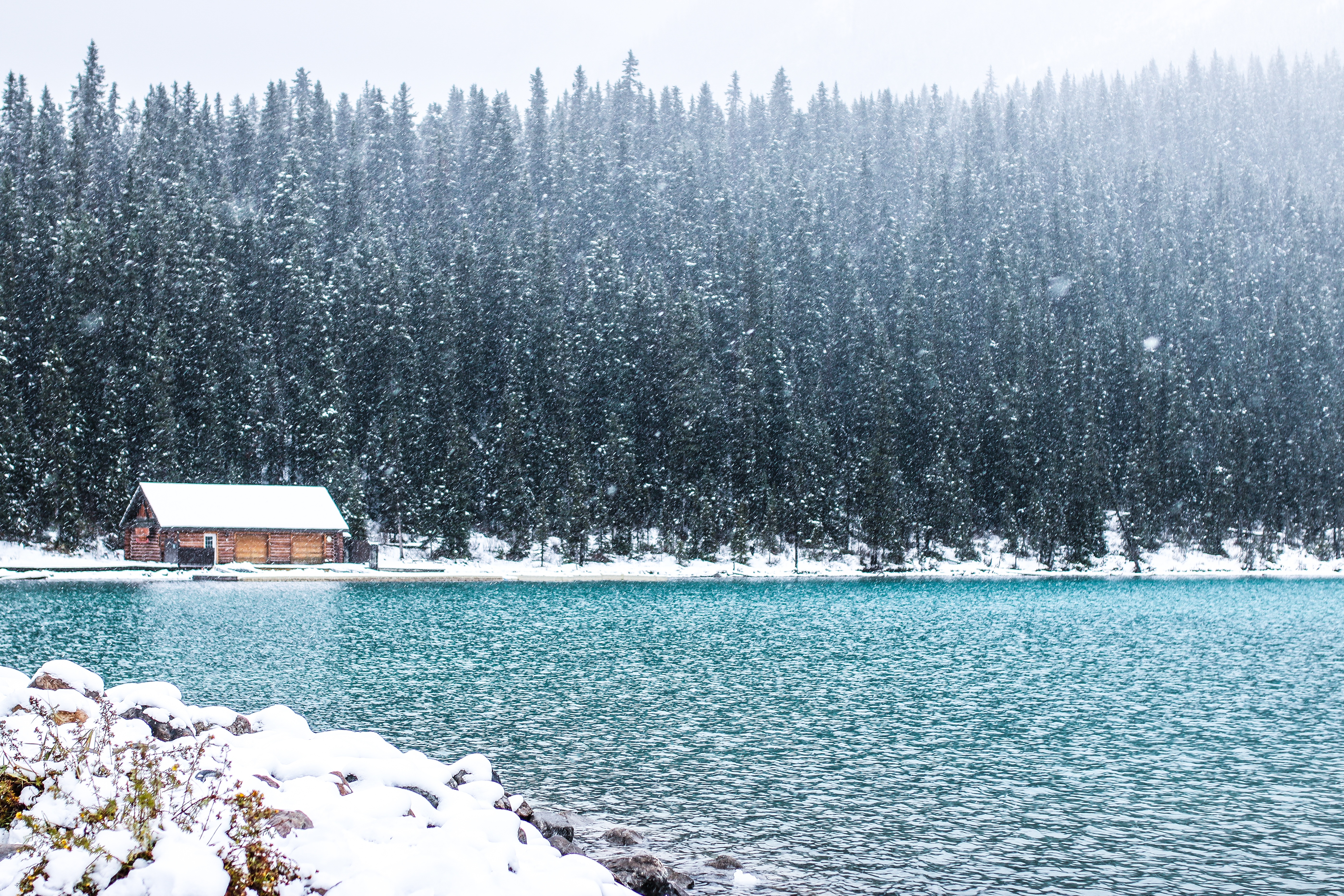 Log cabin on a lake in a snowy forest HD Wallpaper