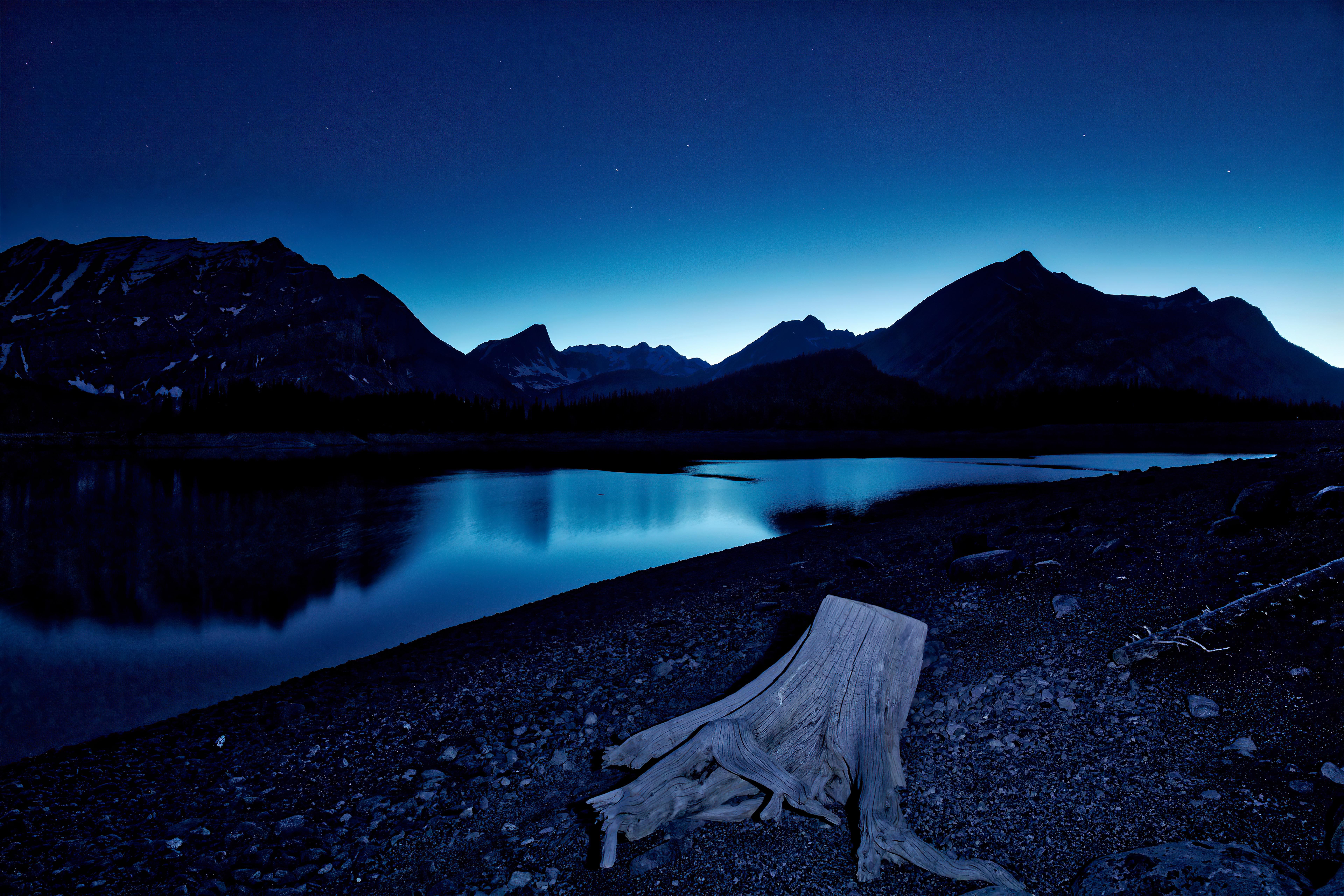 Night sky over mountains and lake with tree stump HD Wallpaper