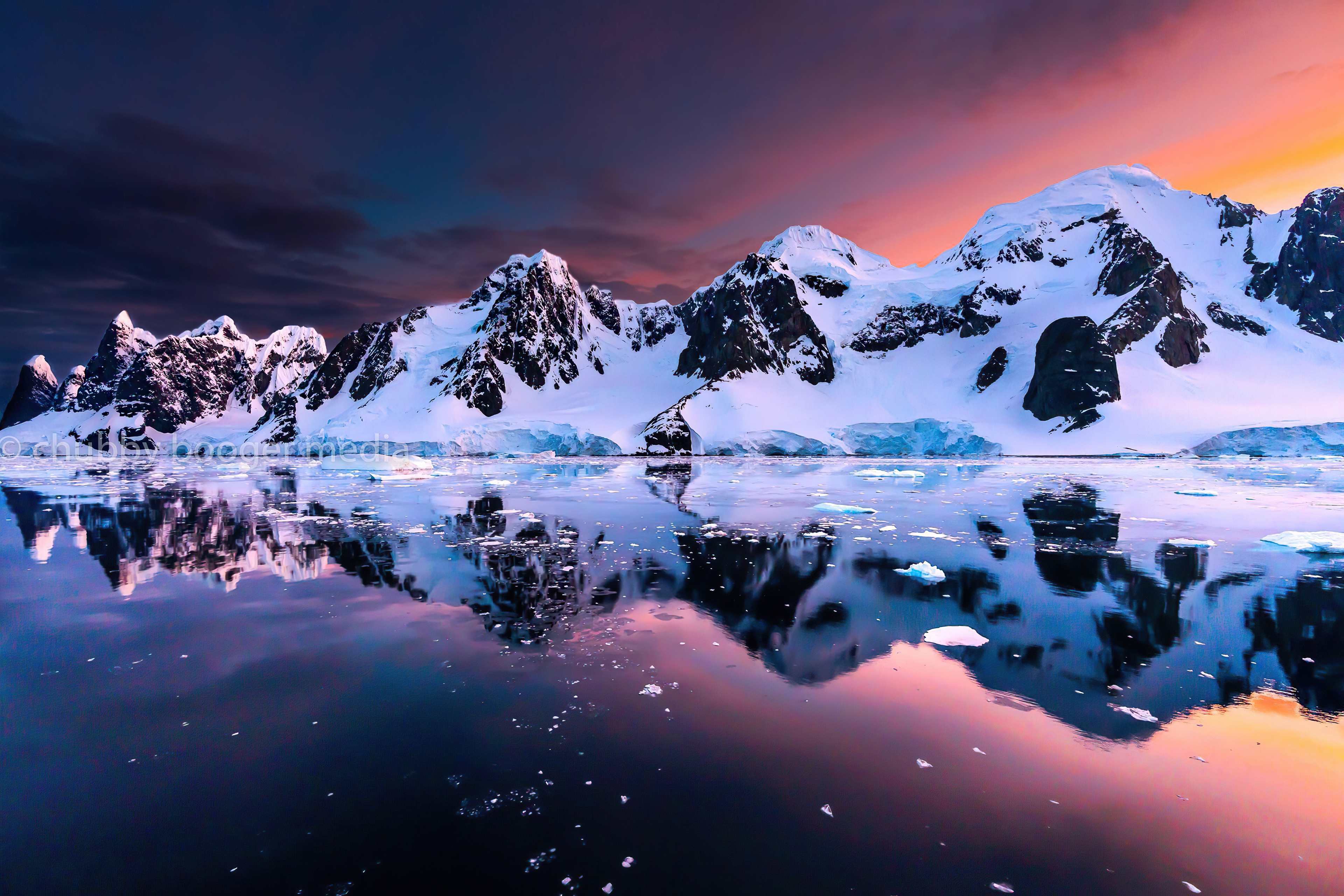 Snowy mountains at sunset reflected in water HD Wallpaper