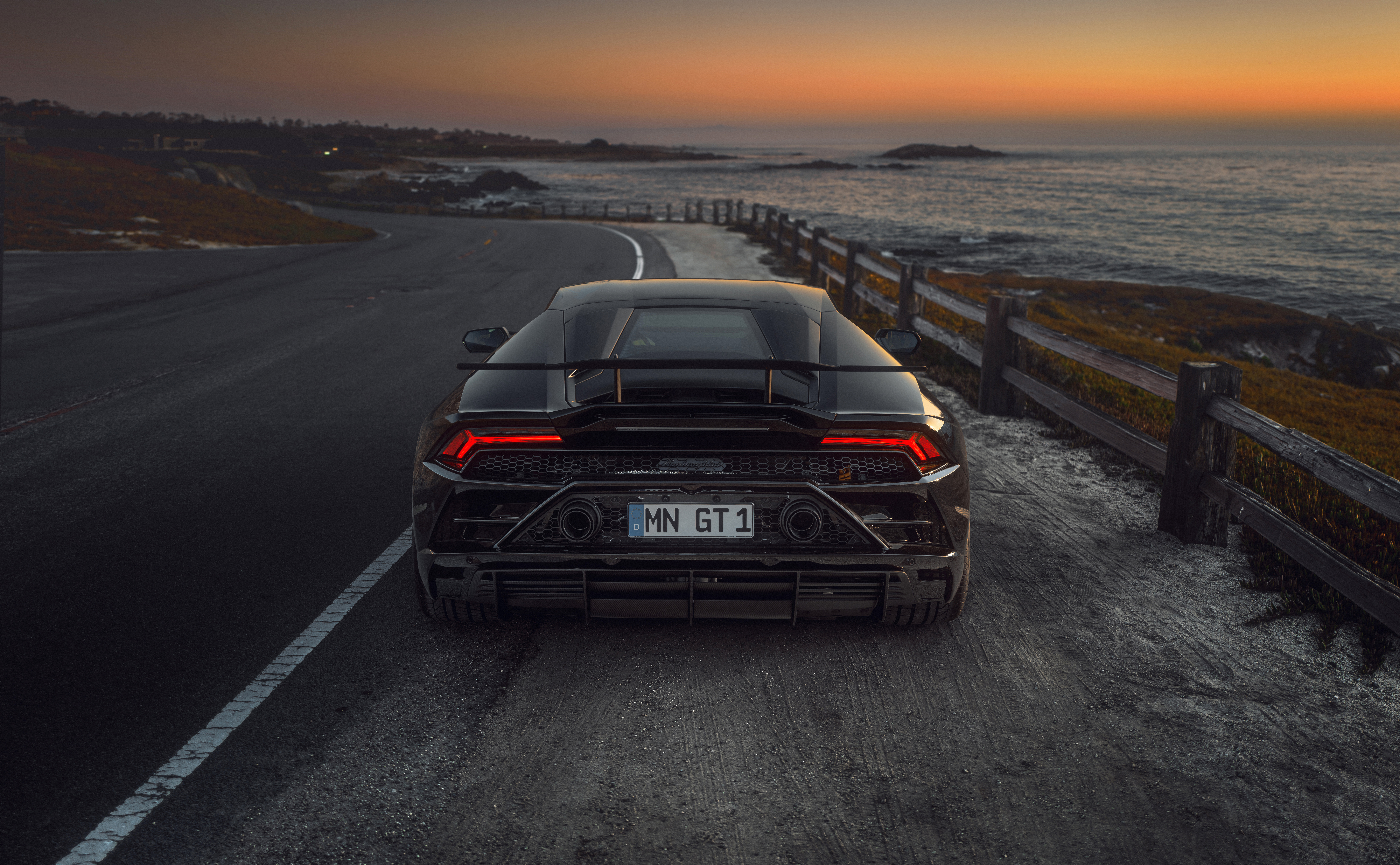 Black Lamborghini Huracan GT 1 on coastal road at sunset HD Wallpaper