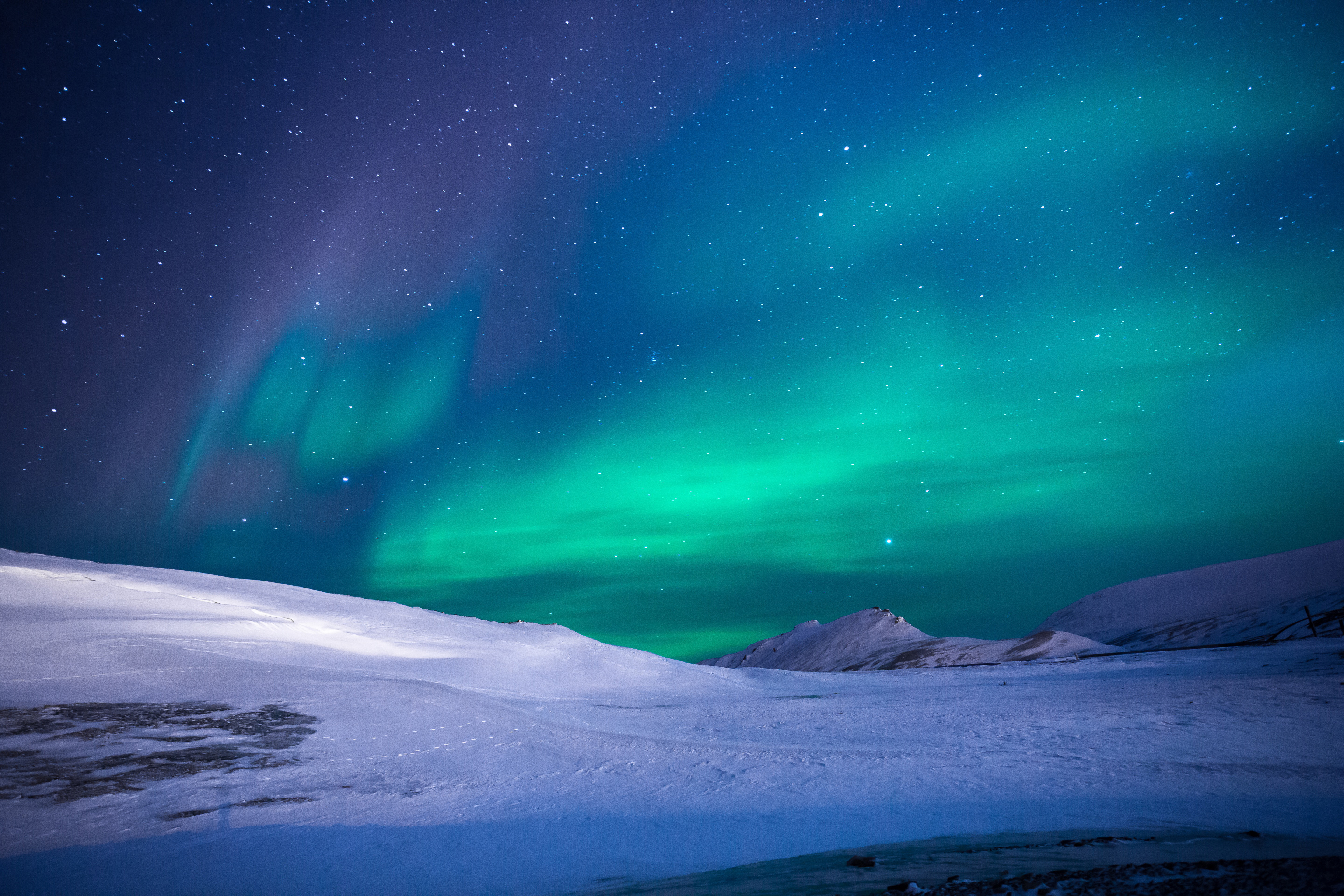 Aurora Borealis over snowy landscape HD Wallpaper