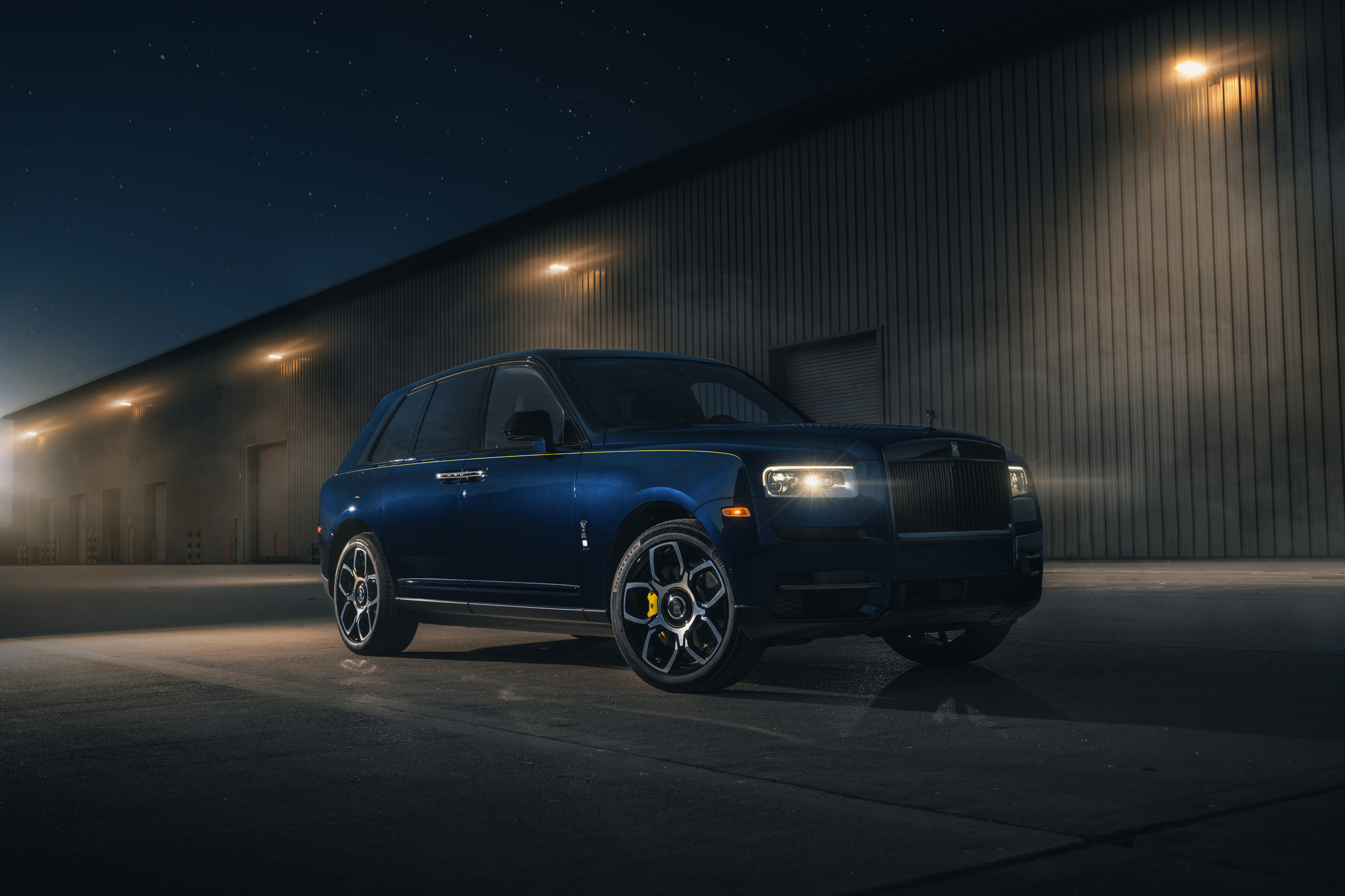 Rolls Royce Cullinan parked outside a warehouse at night HD Wallpaper