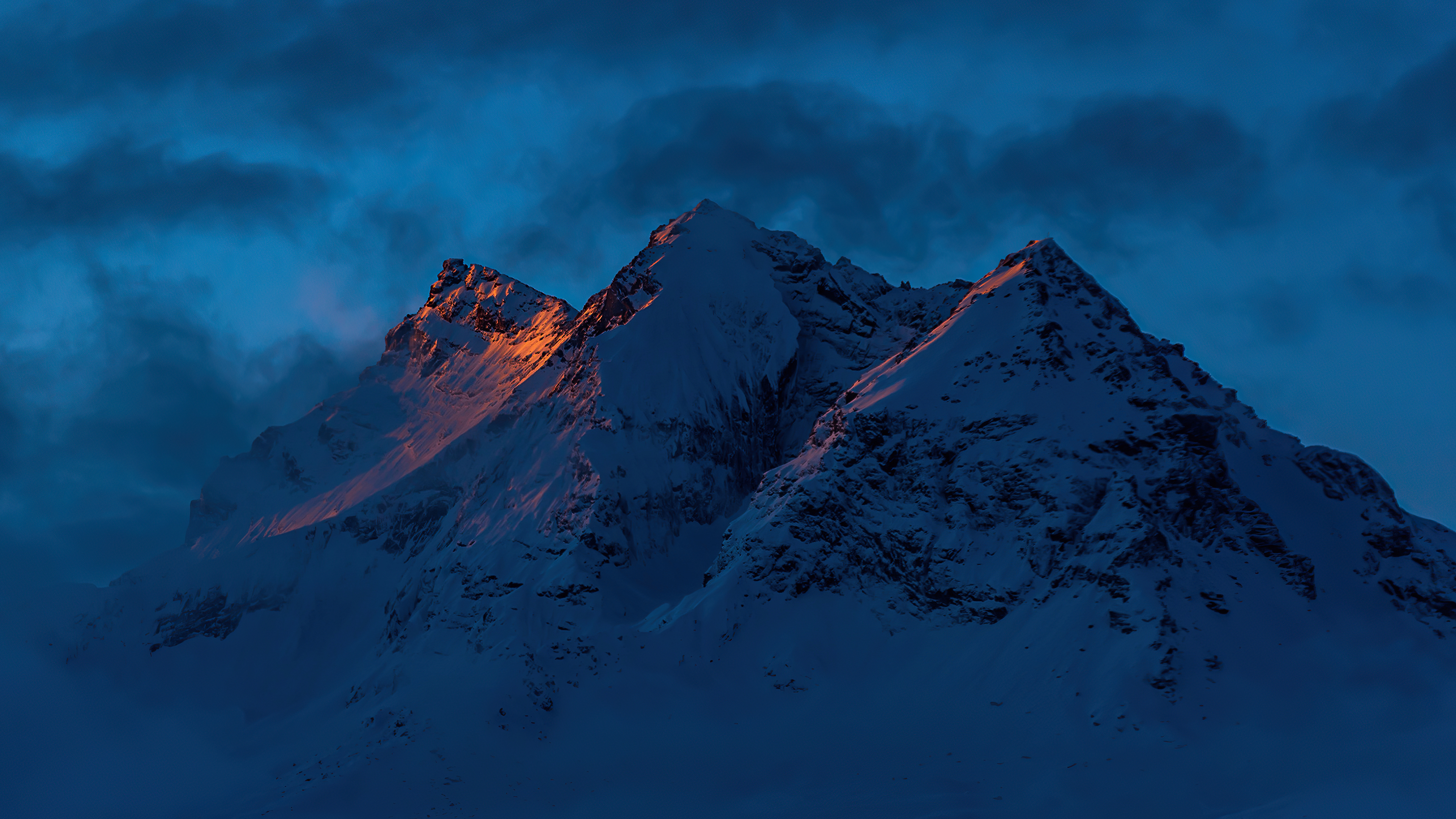 Snowy mountains at dusk with golden light HD Wallpaper