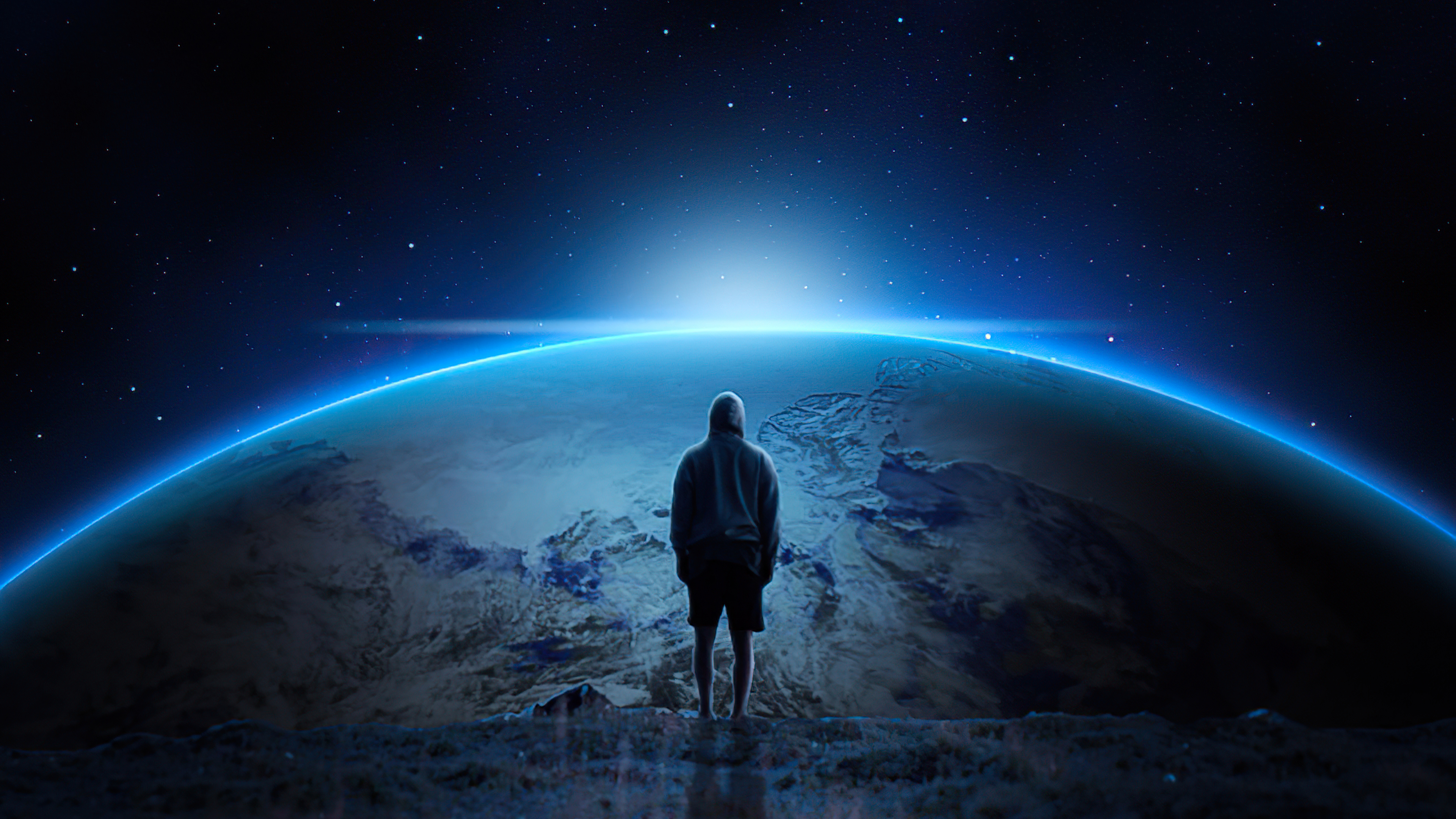 Person in hoodie looking at Earth from space HD Wallpaper