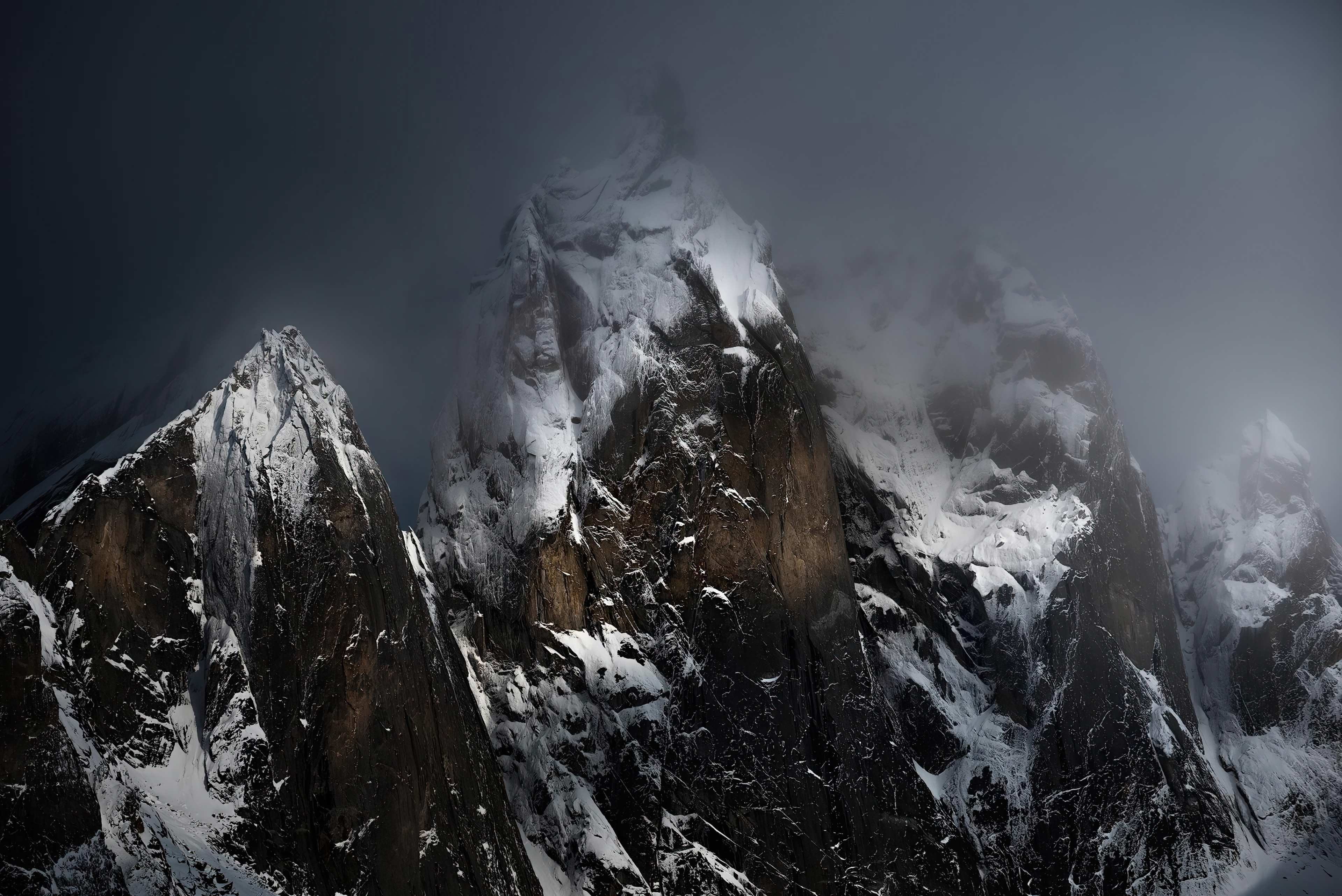 Snow covered mountains in dramatic lighting 4K HD Wallpaper
