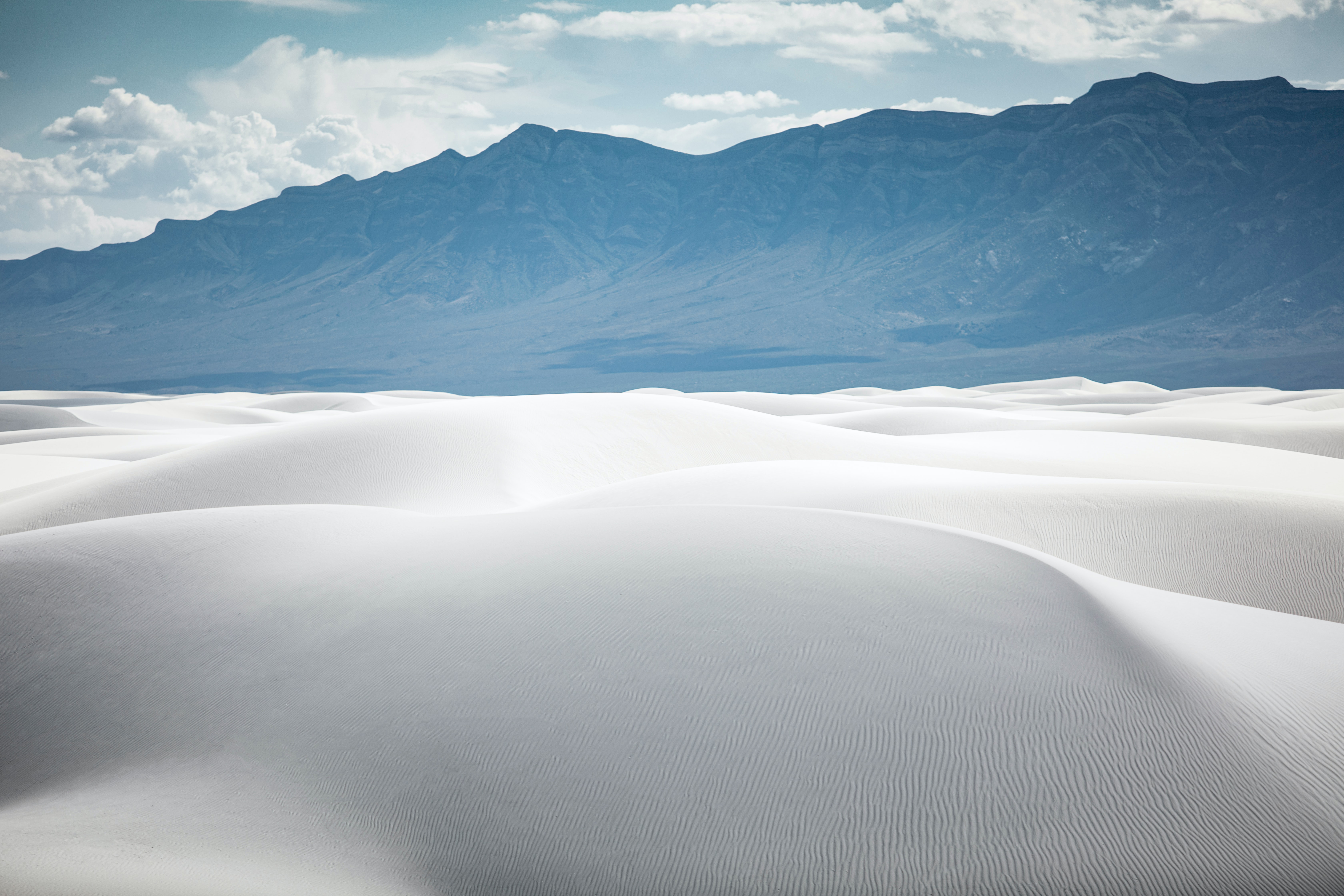 White sand dunes with mountains in the background HD Wallpaper