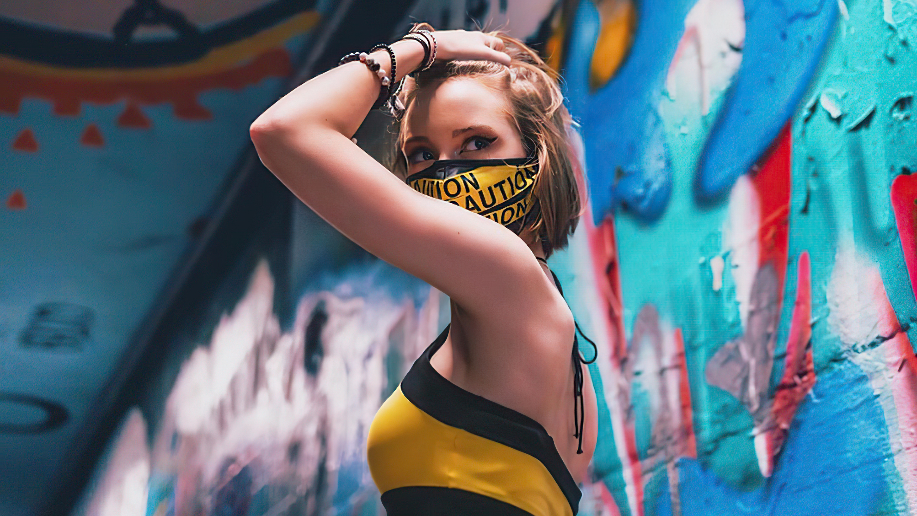 Model wearing caution tape mask and yellow top HD Wallpaper