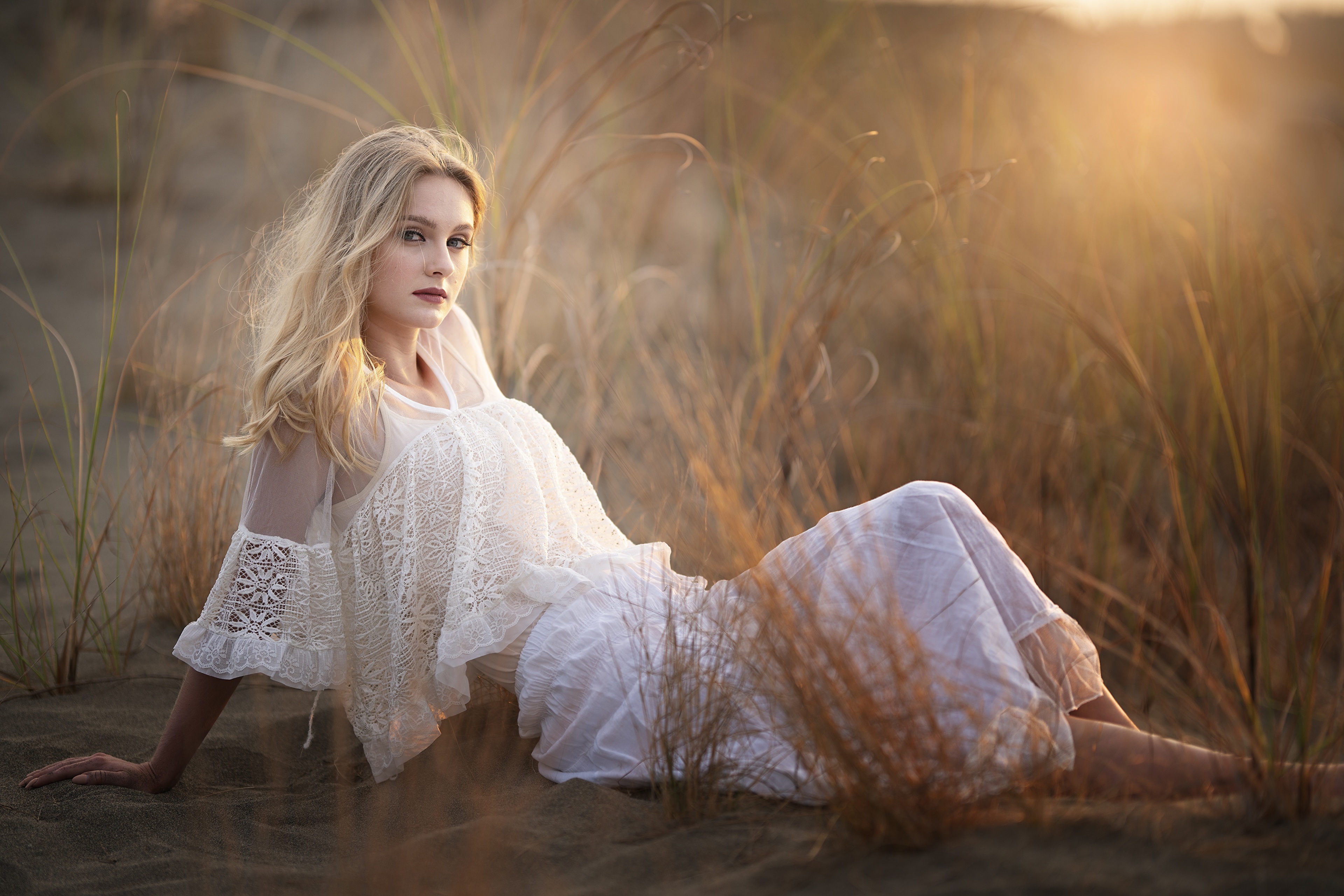Blonde woman in white dress on sand dunes at sunset HD Wallpaper