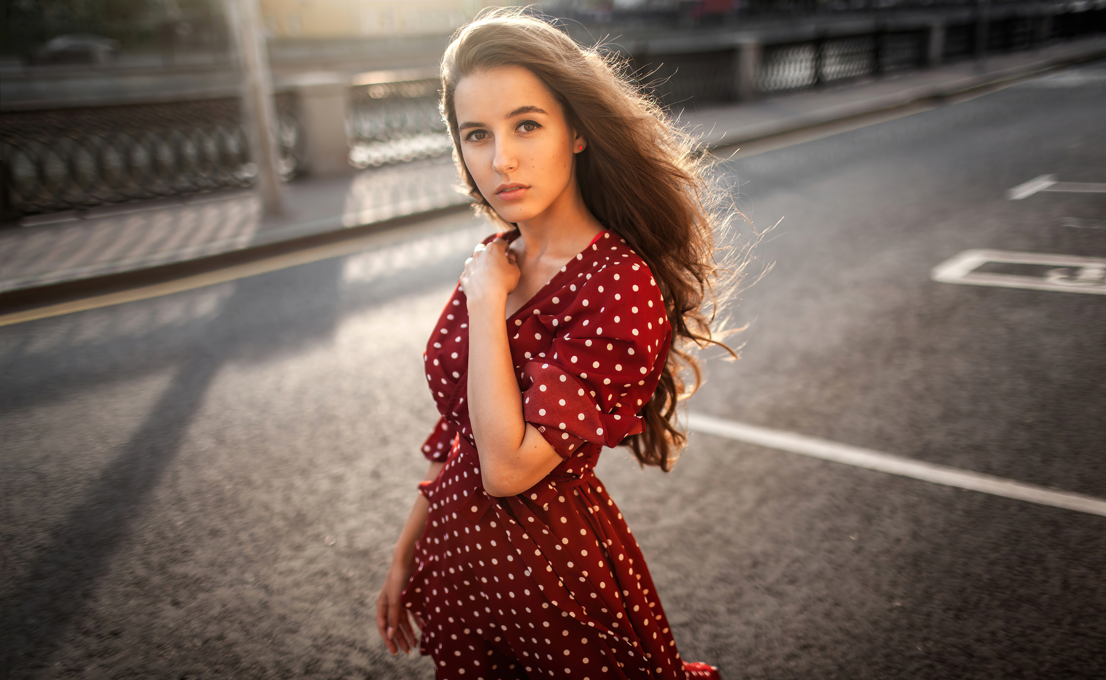 Brunette model in red polka dot dress on street HD Wallpaper