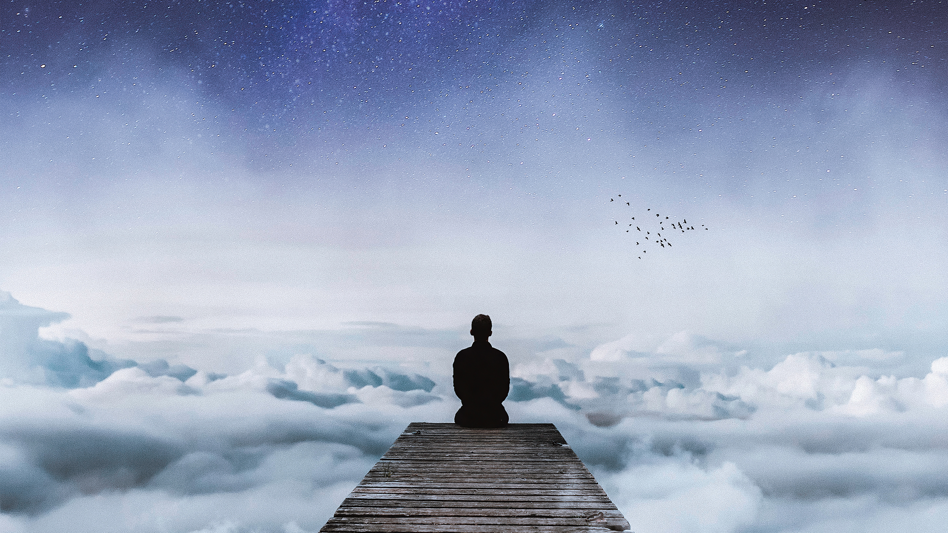 Silhouette of a person meditating on a pier above clouds under a starry sky HD Wallpaper