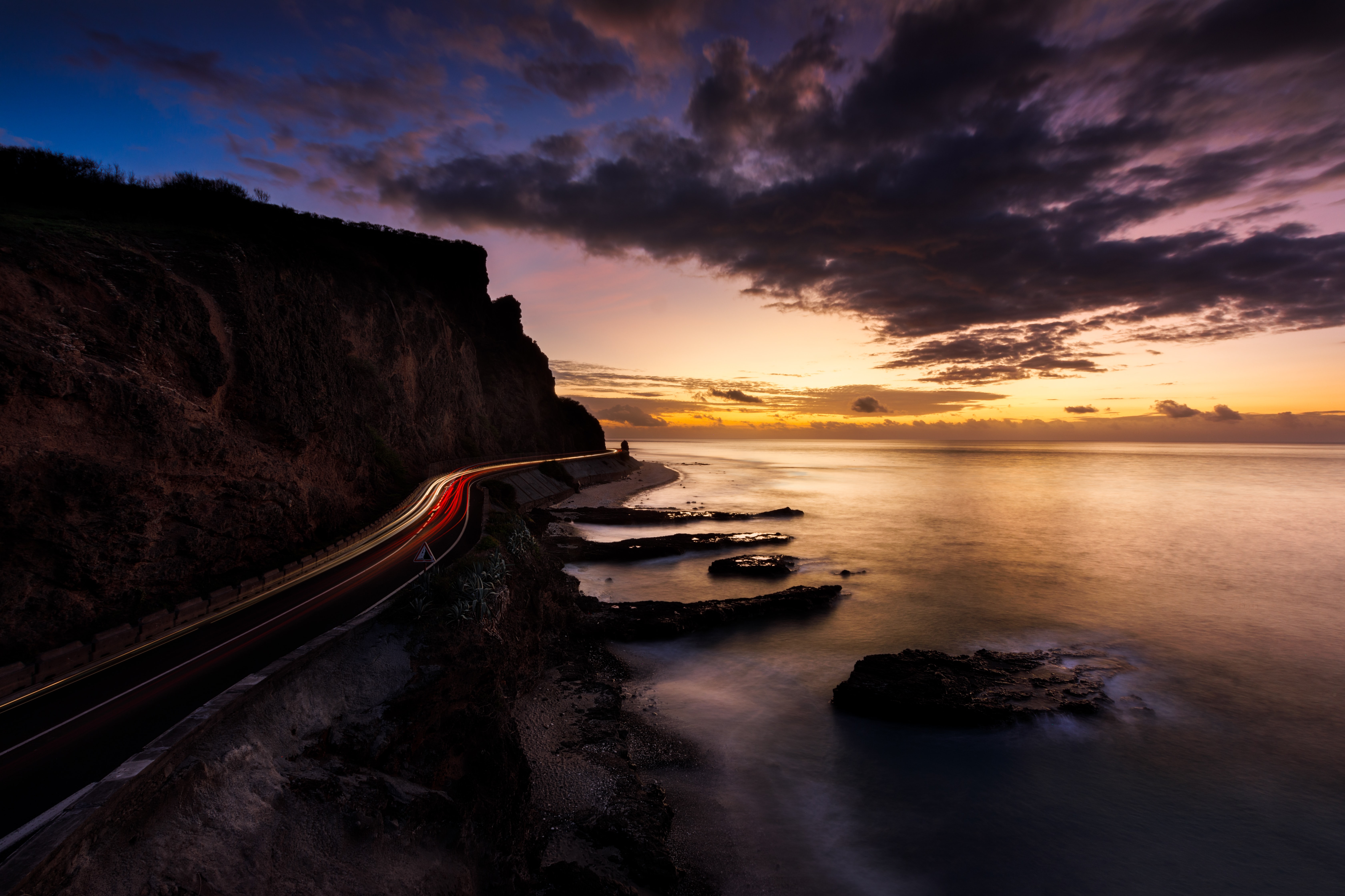 Coastal road with light trails at sunset HD Wallpaper