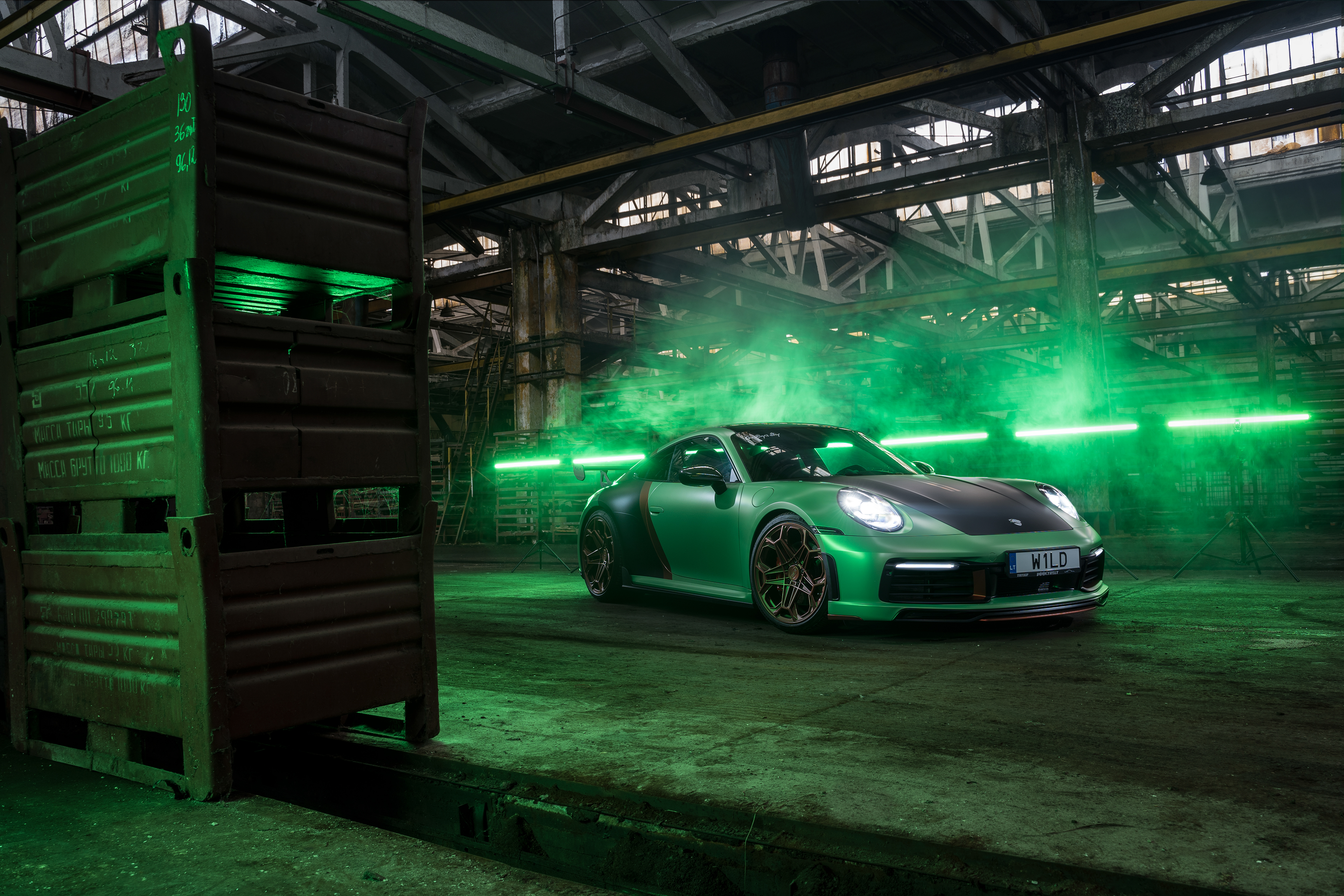 Green Porsche 992 in industrial setting with neon lights HD Wallpaper